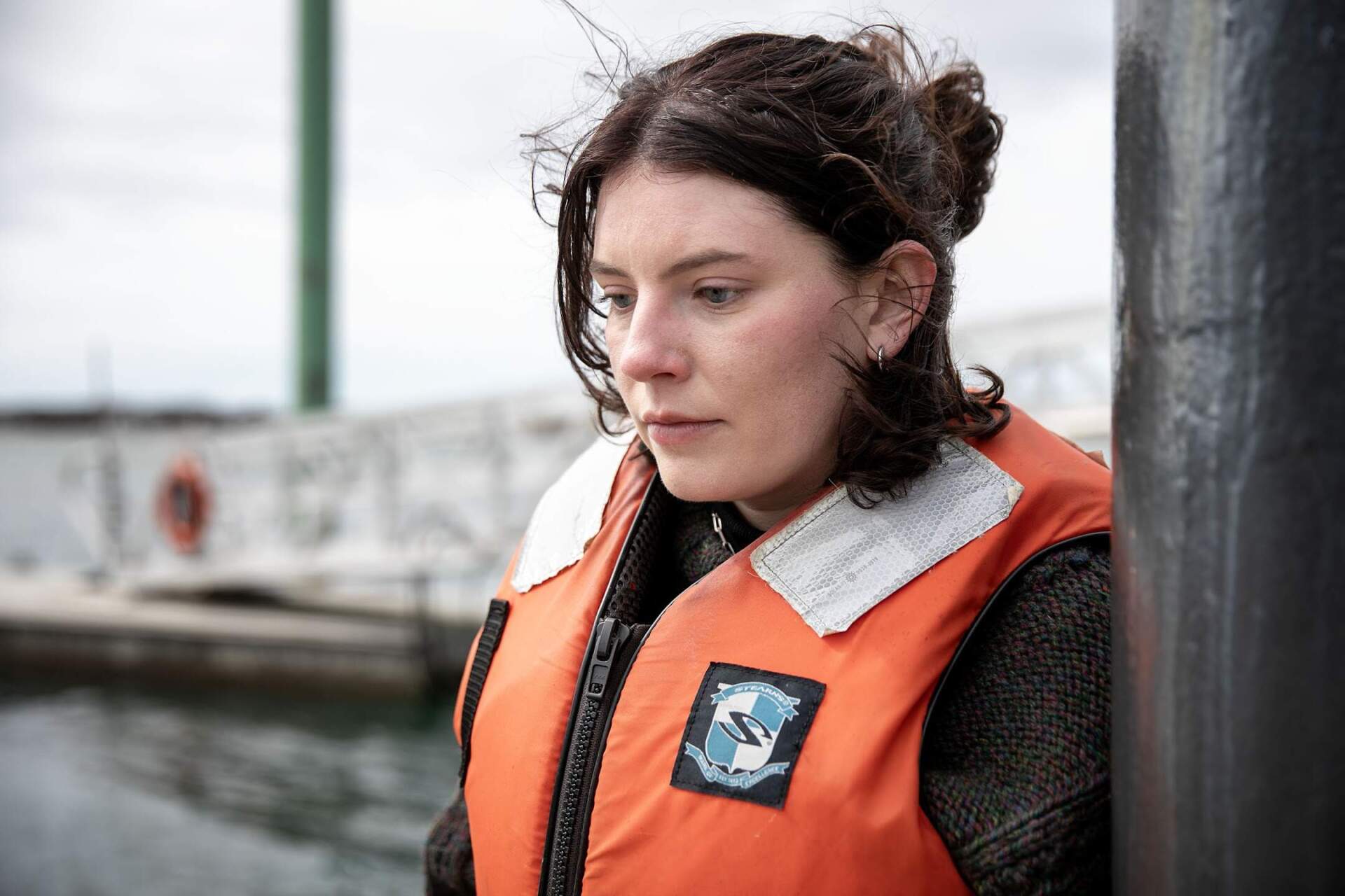 Coastal habitat and water quality specialist Lexie Neffinger watches as students at the Massachusetts Maritime Academy collect specimens from the academy dock. (Robin Lubbock/WBUR)