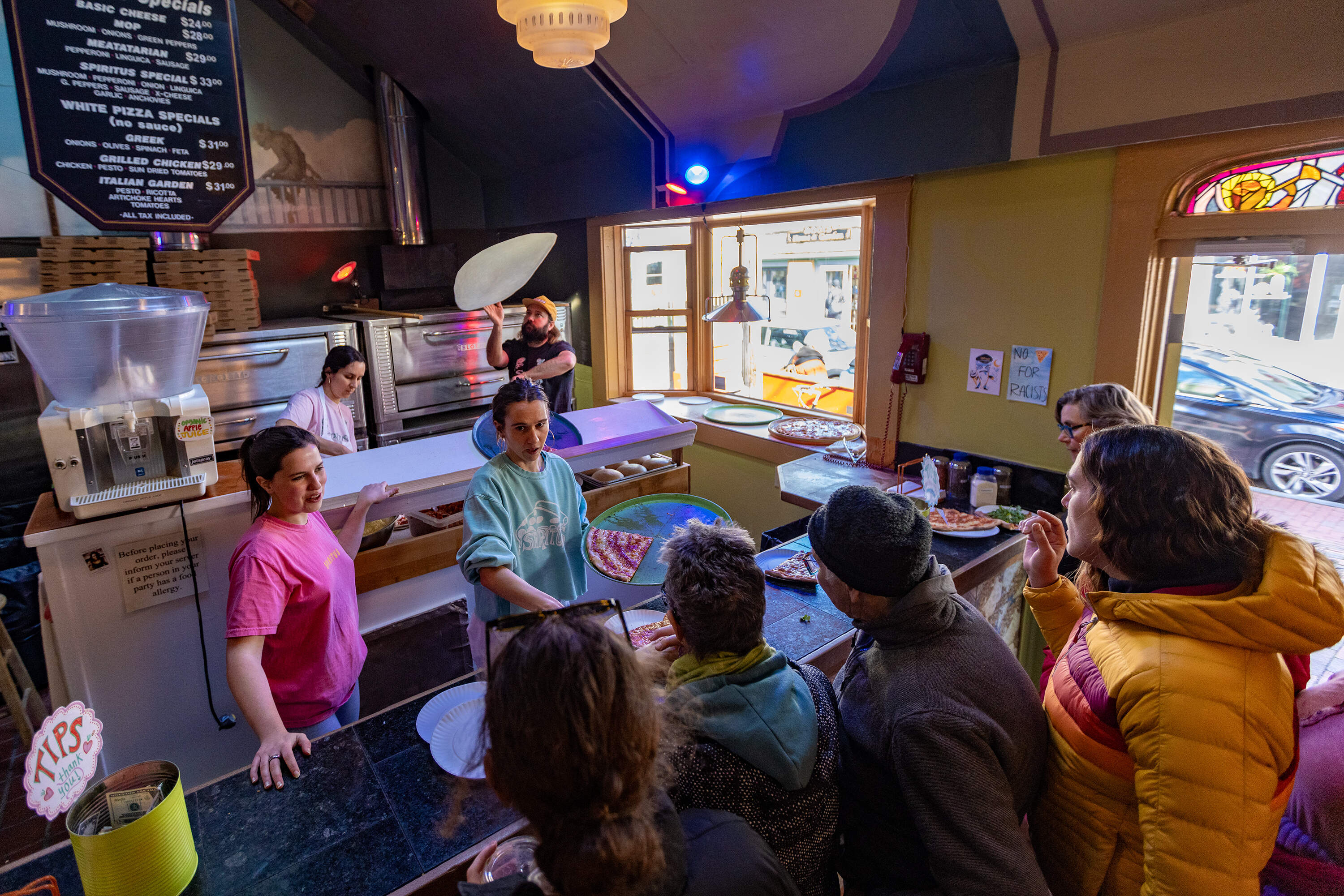 Gui Yingling and his family prepare and serve pizza as customers flock in during the opening day of the season at Spiritus Pizza in Provincetown. (Jesse Costa/WBUR)