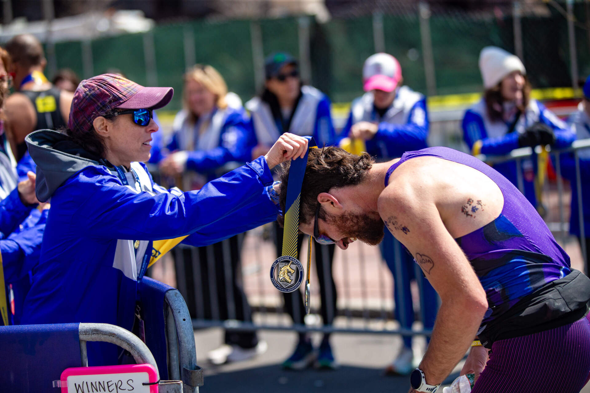 Jack Rose from Panama City Beach, Florida, receives his medal for finishing the Boston Marathon. (Jesse Costa/WBUR)
