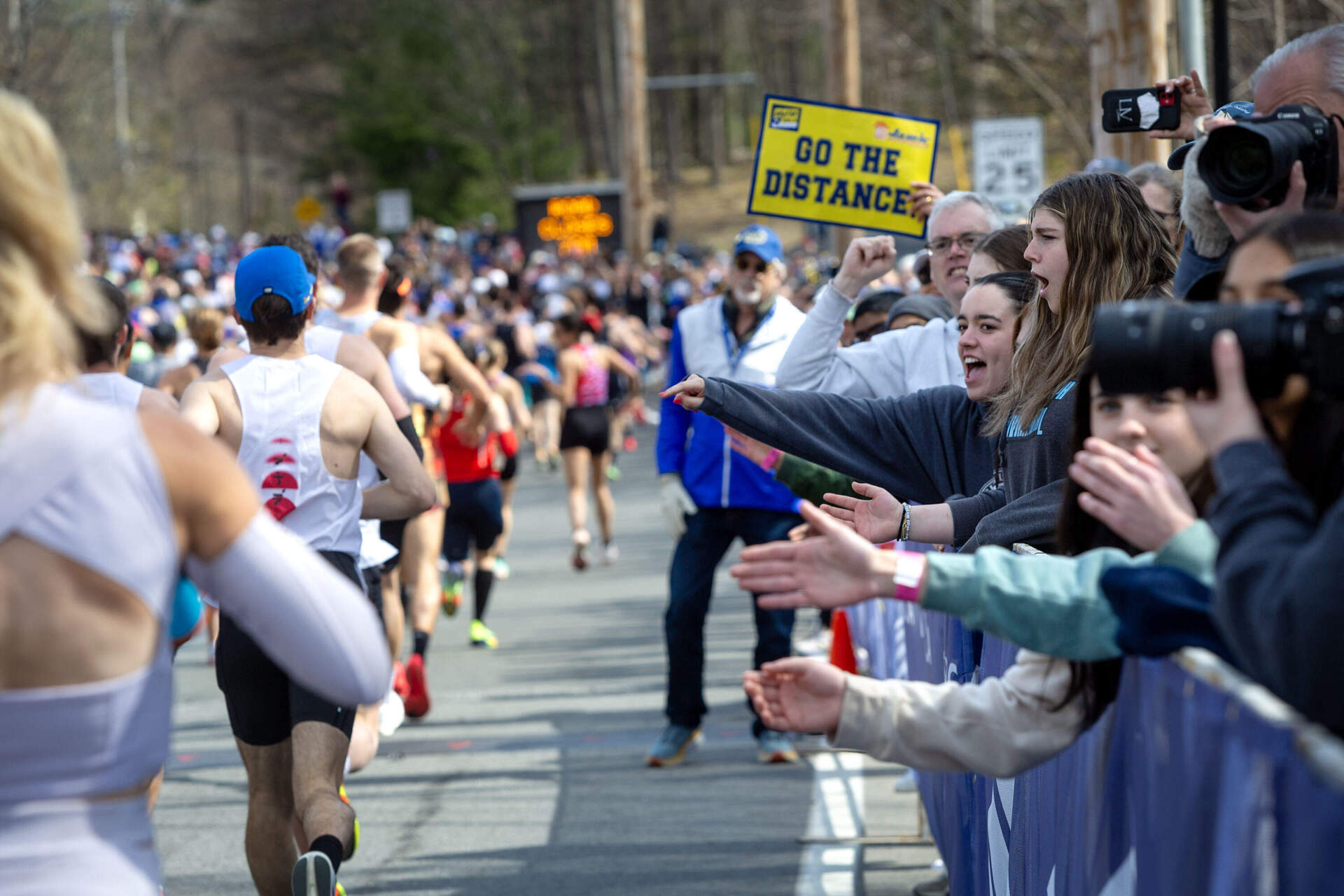 Boston Marathon spectators cheer on runners as they make their way down the hill from the starting line. (Robin Lubbock/WBUR)