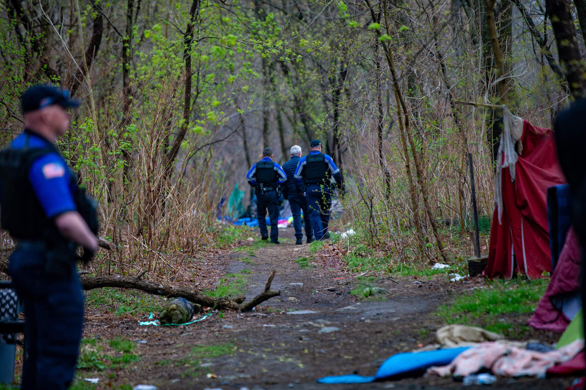 Lowell Police monitored the removal of the homeless encampment, and officers on the city's outreach team talked with encampment residents about services available to them. (Jesse Costa/WBUR)
