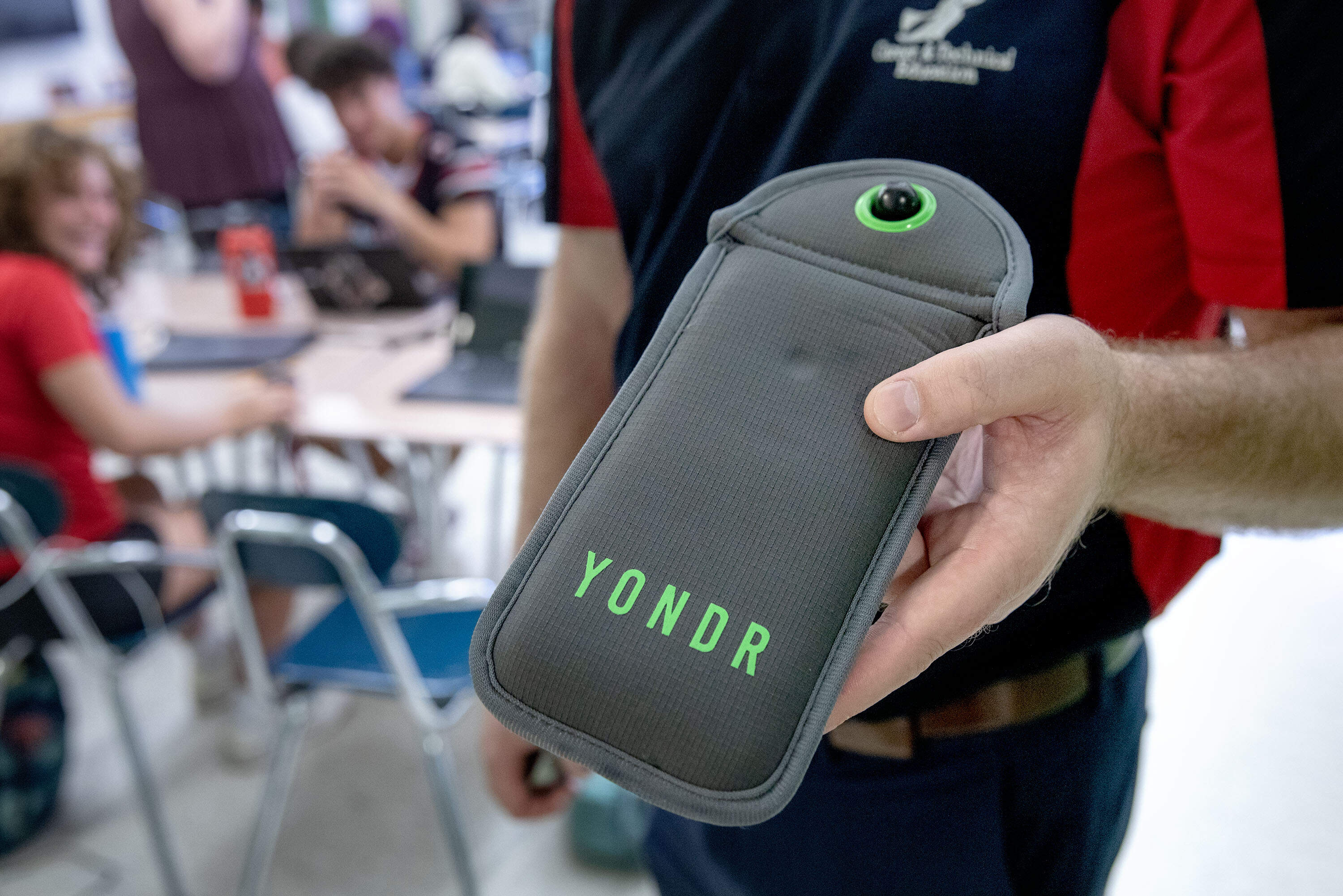 Salem High School Principal Glenn Burns holds a locked phone pouch holding a student's phone. (Robin Lubbock/WBUR)