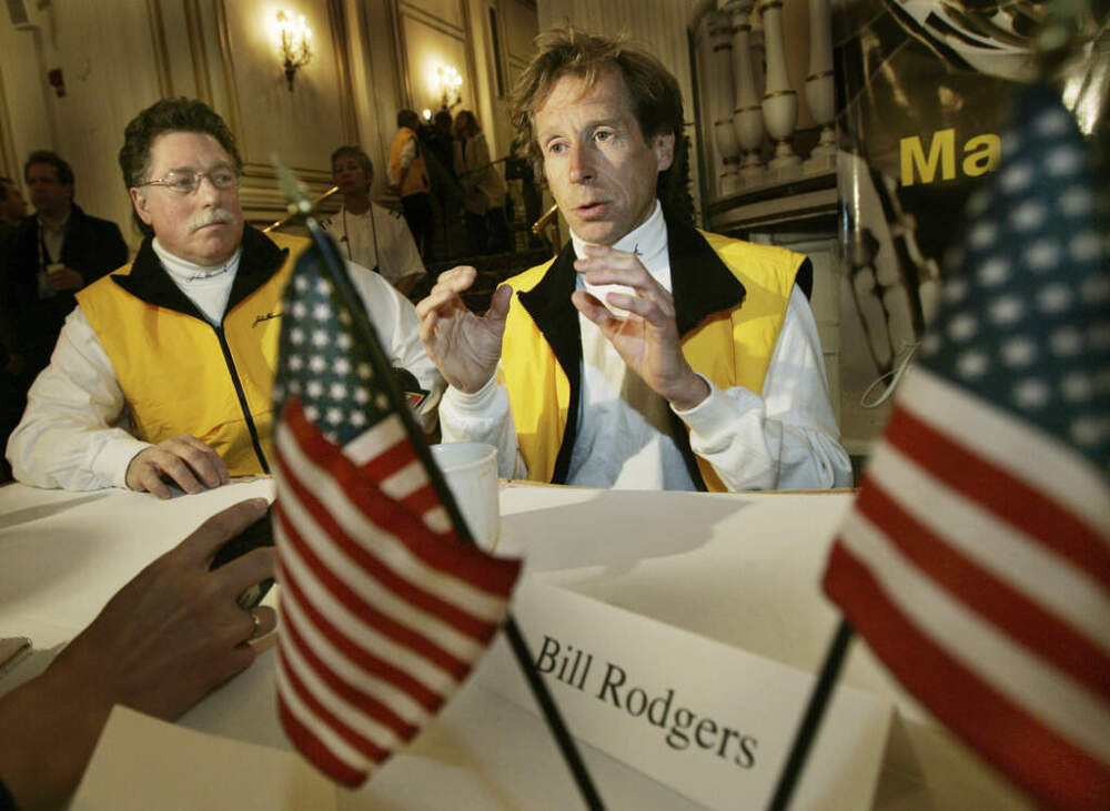 Four-time Boston Marathon winner, Bill Rodgers, speaks, as Boston Marathon wheelchair winner and pioneer, Bob Hall, listens at left, during a news conference in Boston, April 15, 2005. (Elise Amendola/AP)