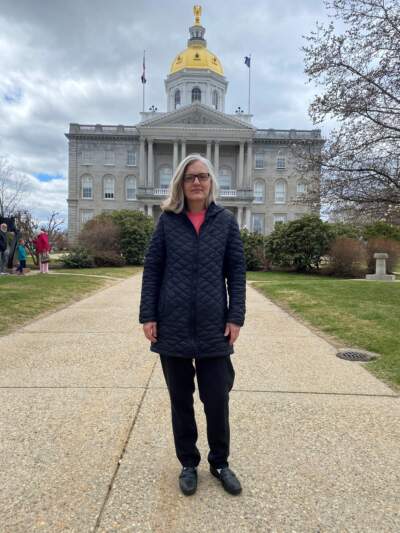 Betsy Harrington of Dearing, New Hampshire, in front of the State House in Concord, where lawmakers are considering legislation that would make it easier to remove books from school libraries and classrooms. (Anthony Brooks/WBUR)
