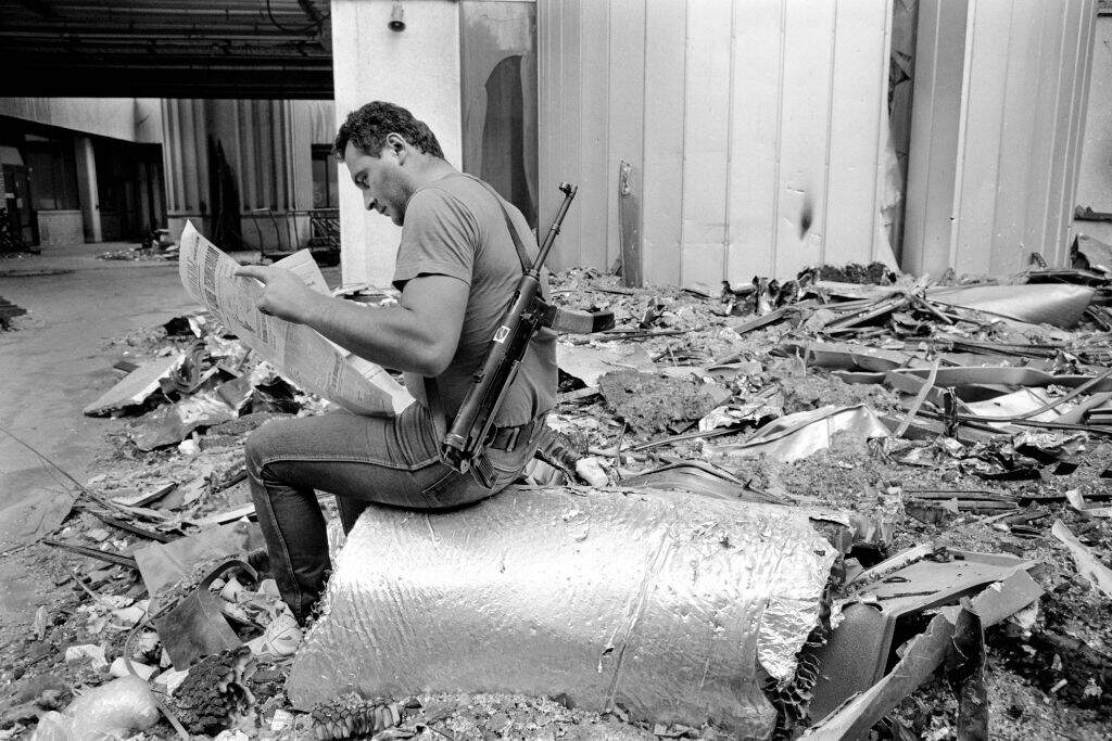 A Bosnian fighter reads a copy of Oslobodenje at the Sarajevo newspaper's destroyed offices in Sarajevo, Bosnia, in July 1992. During the 47-month siege of Sarajevo, more than 10,600 people were killed and 56,000 wounded or maimed. (Getty Images)
