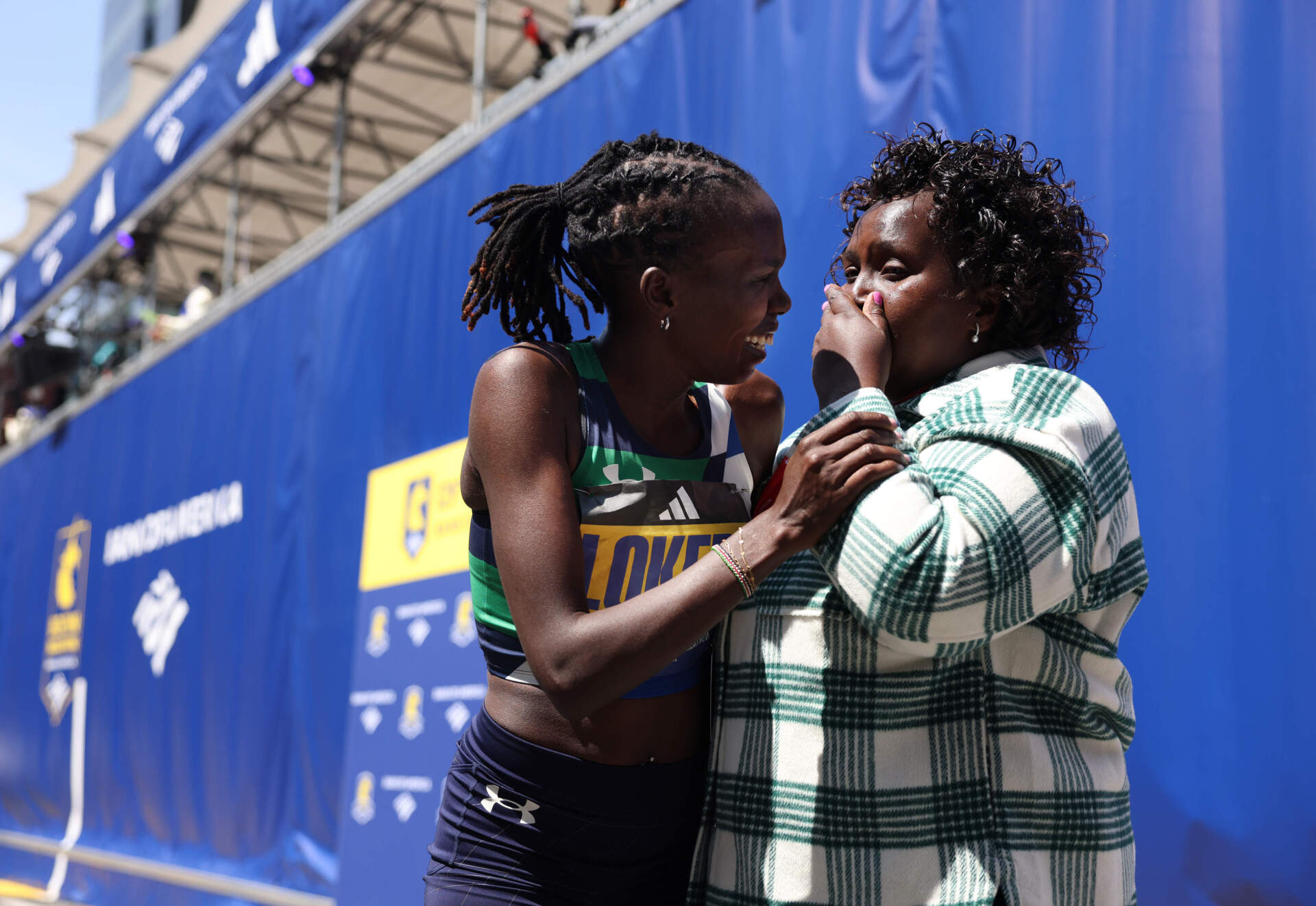 Women's winner Sharon Lokedi celebrates with her mother, Rose, after crossing the finish line. (Jessica Rinaldi/The Boston Globe via Getty Images)