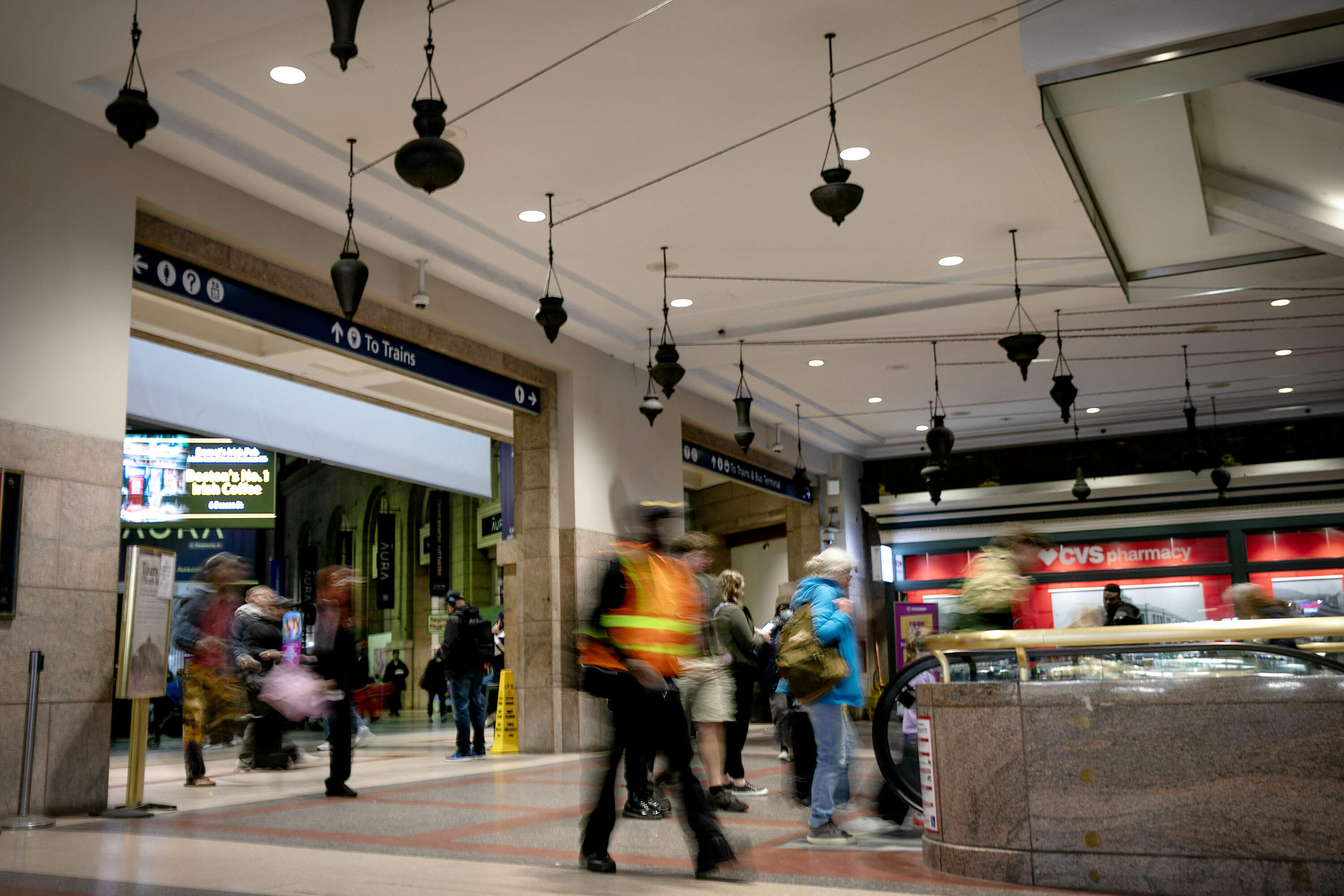 People walk through the main entrance to Boston's South Station beneath Destinations by artist Jeffrey Schiff. (Robin Lubbock/WBUR)