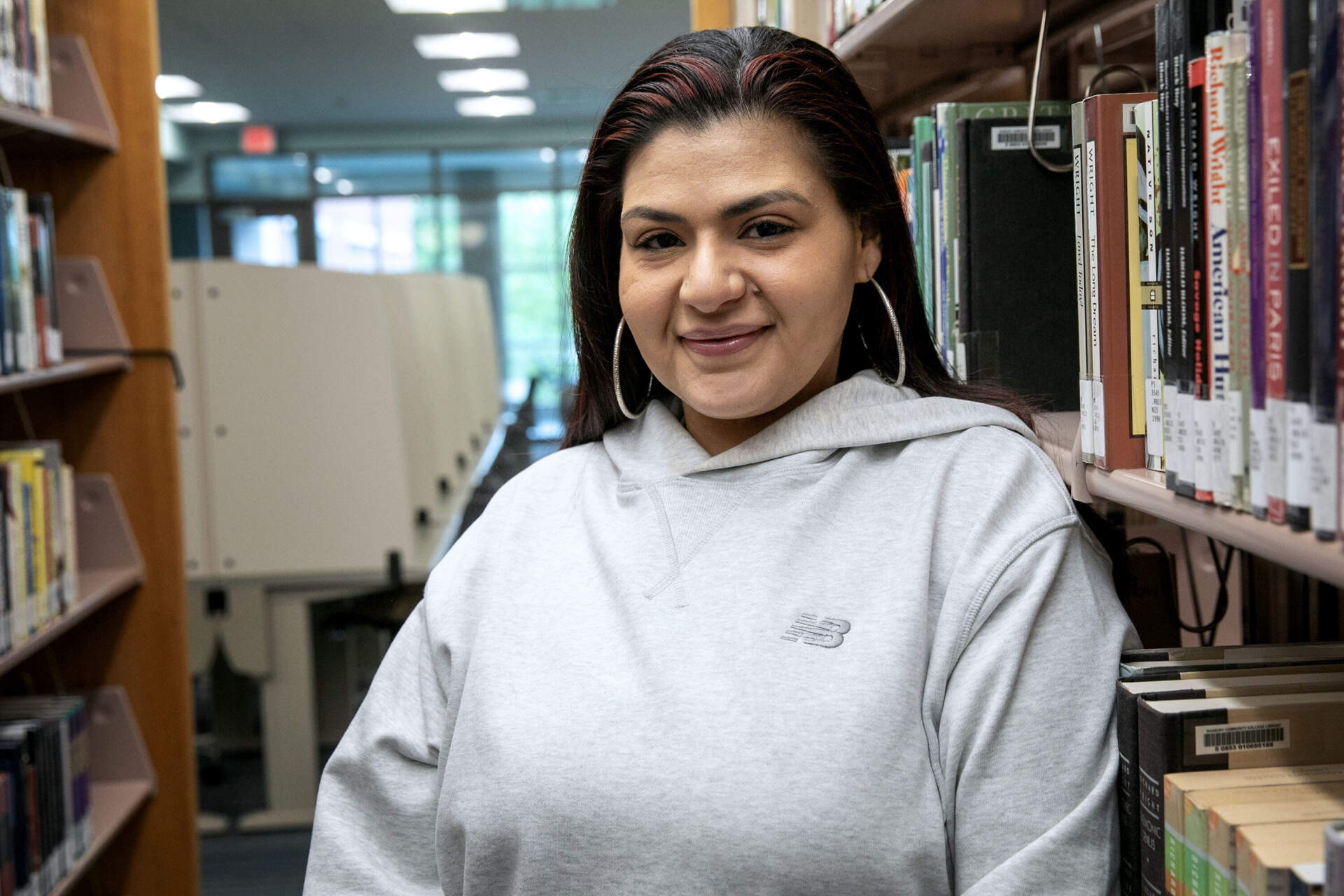 Kiara Rosario stands in the library at Roxbury Community College. (Robin Lubbock/WBUR)