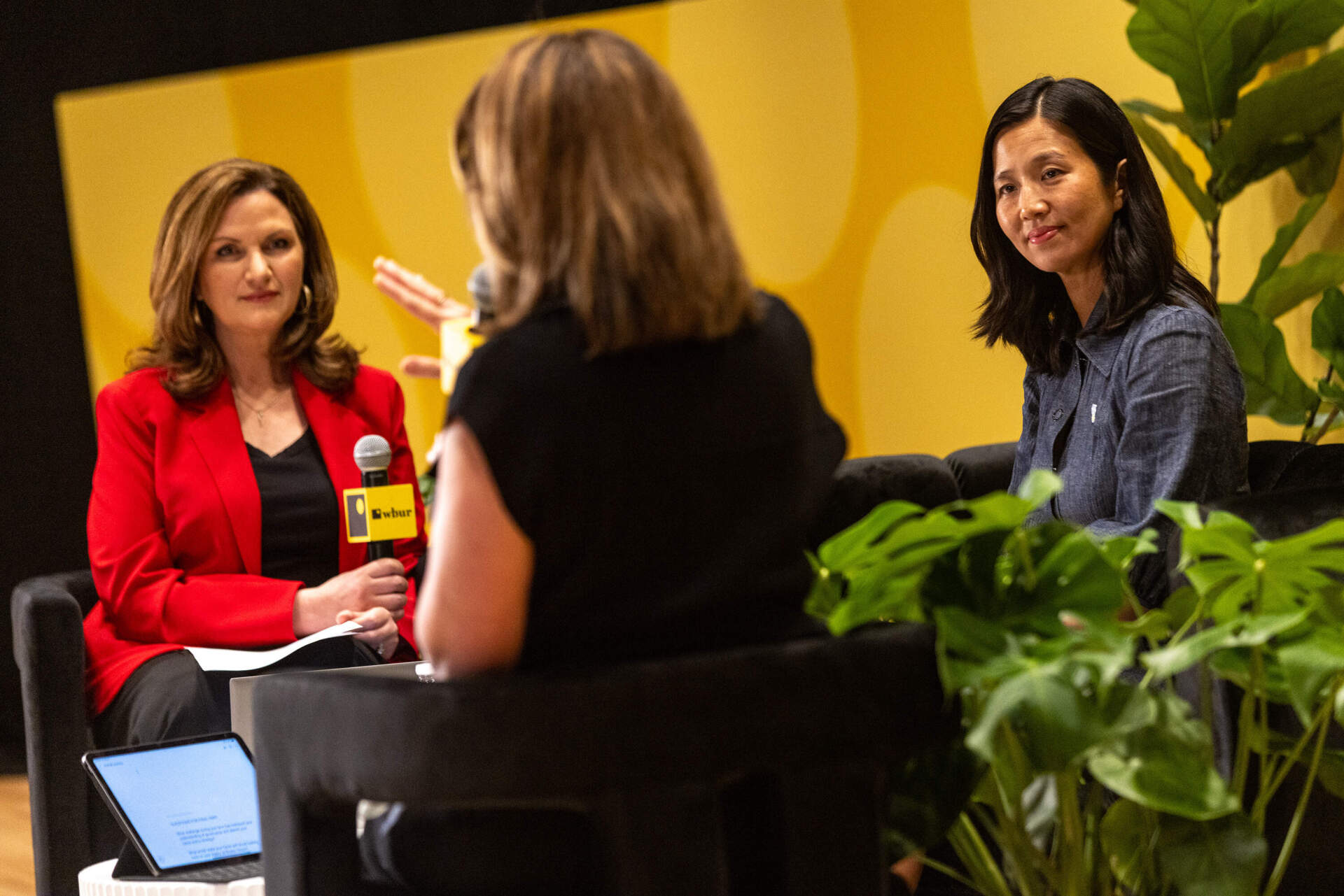 WCVB's Sharman Sacchetti, Boston Mayor Michelle Wu and WBUR's Tiziana Dearing on stage Friday. (Jesse Costa/WBUR)