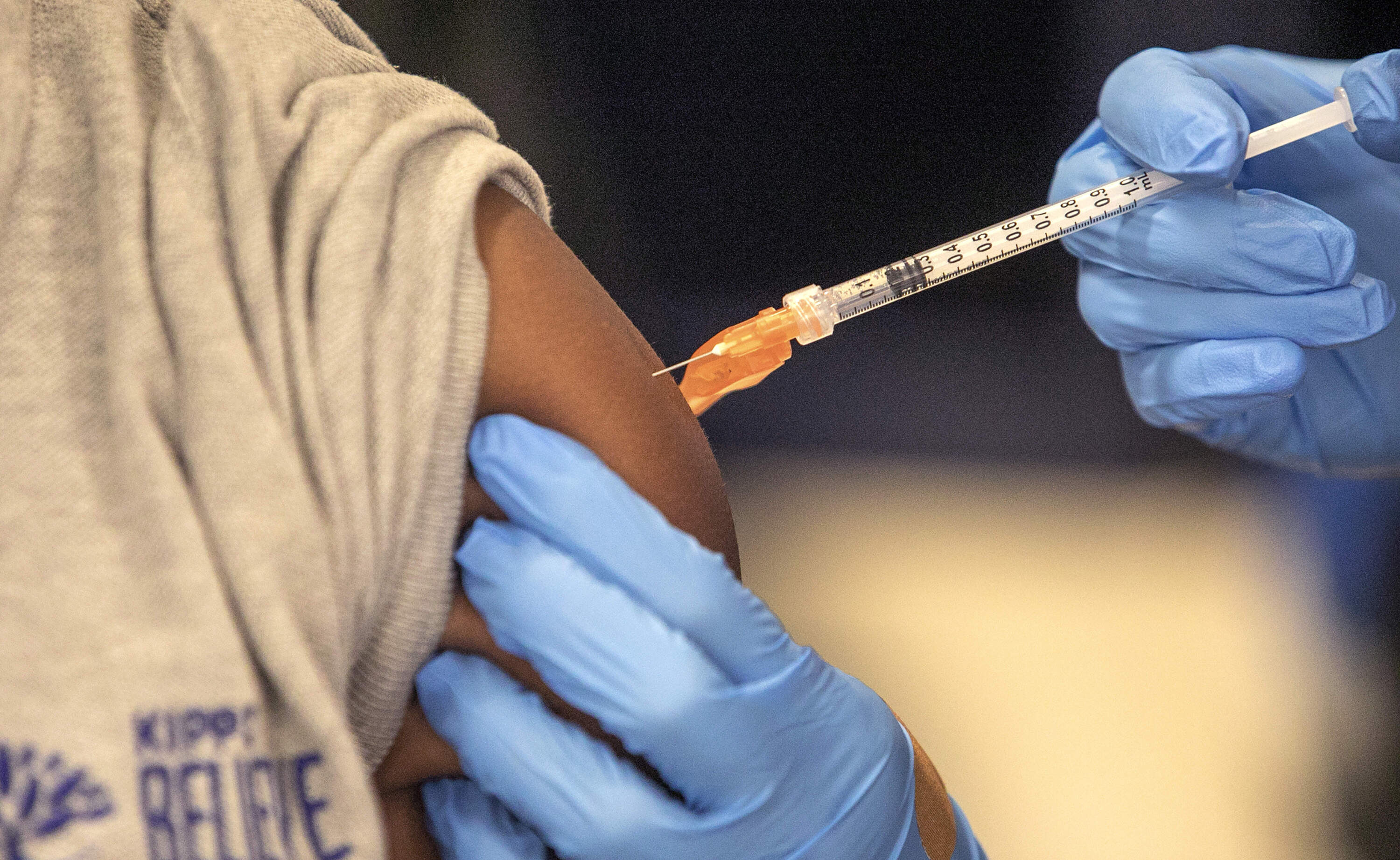 Medical personnel vaccinate students at a school in New Orleans on Jan. 25, 2022. (Ted Jackson/AP)
