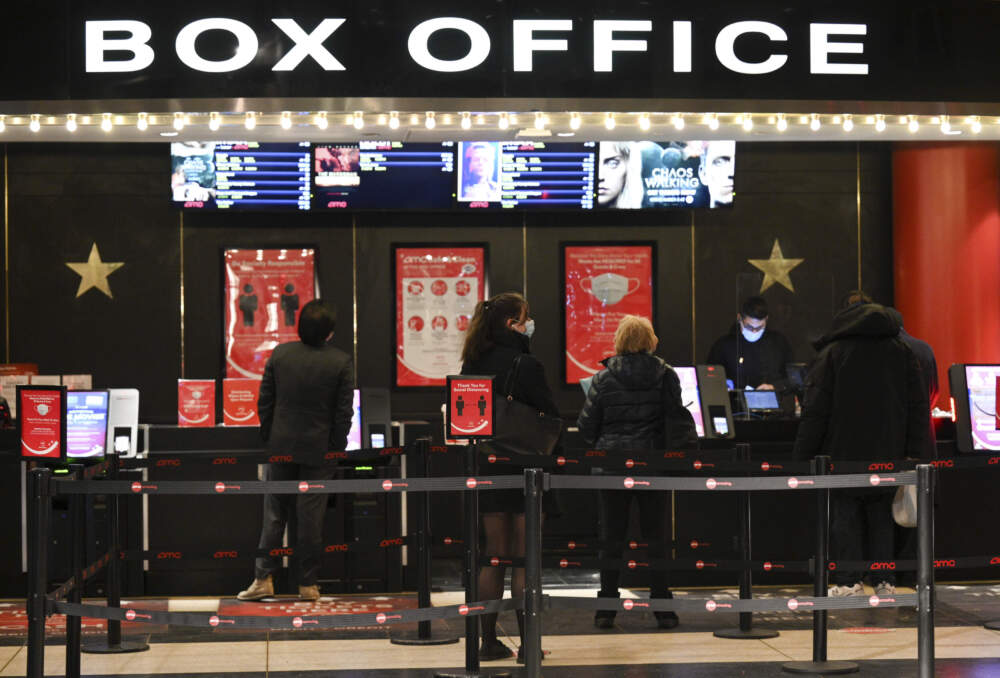 People purchase tickets at a movie theater in New York on March 5, 2021. (Evan Agostini/Invision/AP, File)