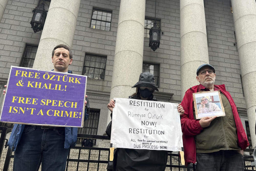 Protesters hold up signs outside a federal appeals court on Tuesday. A panel of judges heard arguments in the cases of a Turkish Tufts University student who has been detained by immigration authorities for six weeks and a Palestinian student at Columbia University who was recently released from detention. (David Martin/AP)