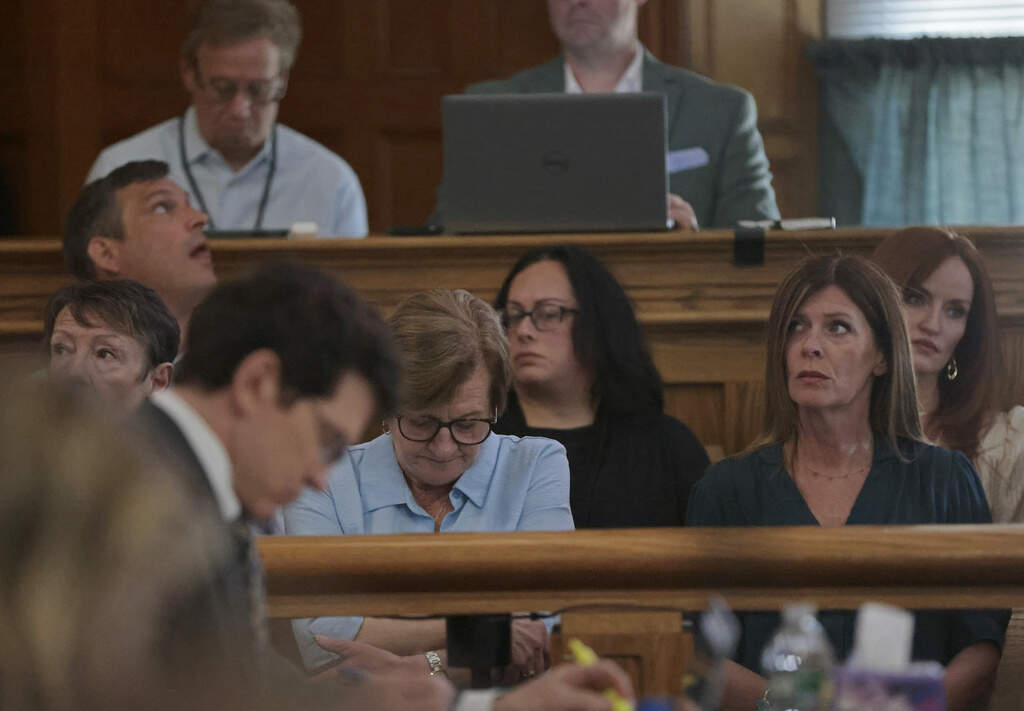 Peggy O'Keefe, center, diverts her eyes when the right arm of her son, Boston Police officer John O'Keefe, is projected during the trial. (Pat Greenhouse/The Boston Globe)