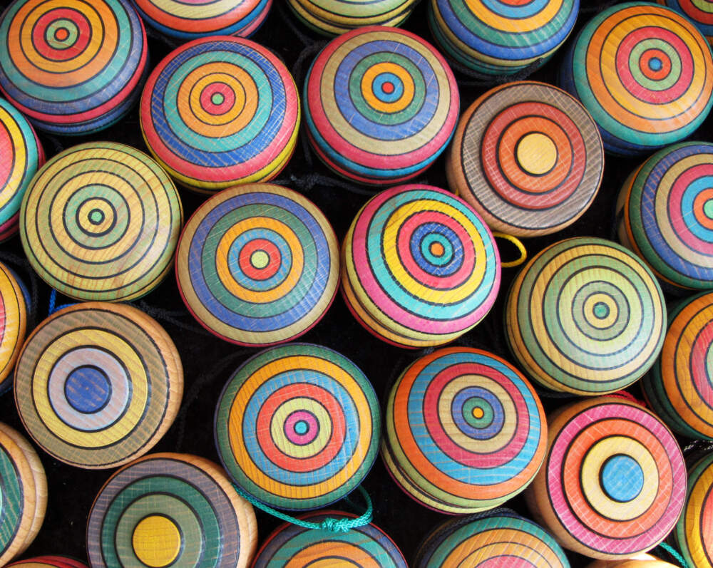 Close-up of collection of various wooden yoyos painted with colorful circles. (Getty Images)