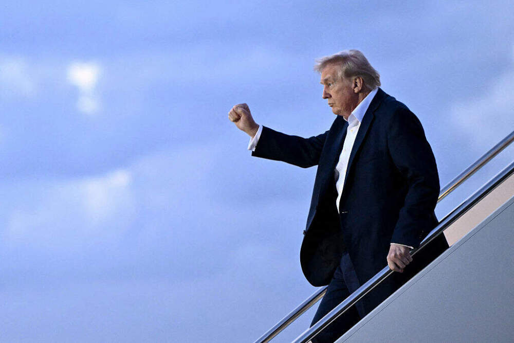 President Donald Trump raises a fist as he steps off Air Force One at Palm Beach International Airport in West Palm Beach, Florida, on April 11. (Mandel Ngan/AFP via Getty Images)