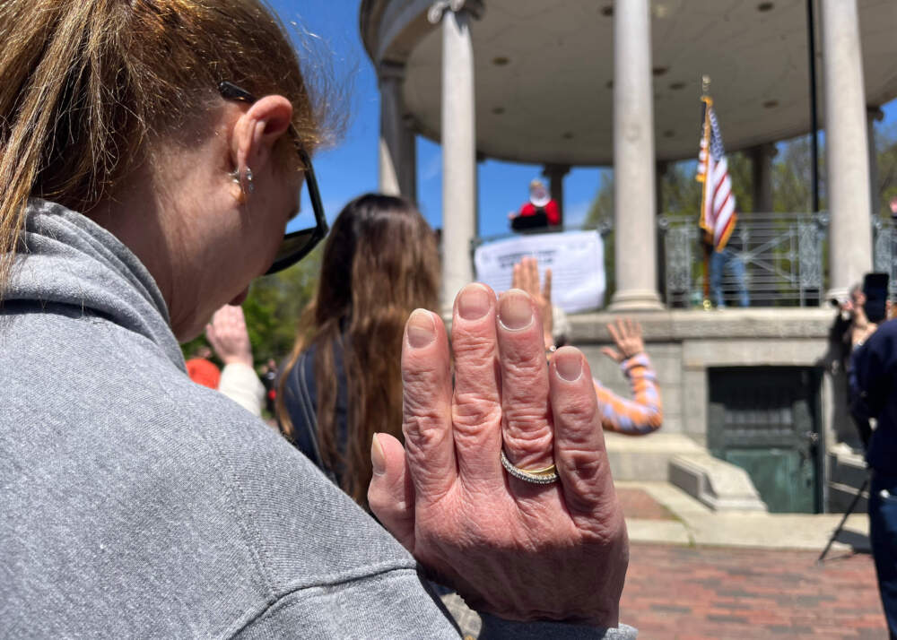 Cynthia Granata raises her right hand while symbolically renewing the lawyer's oath of office at a protest on Boston Common. (Chloe Jad/WBUR)