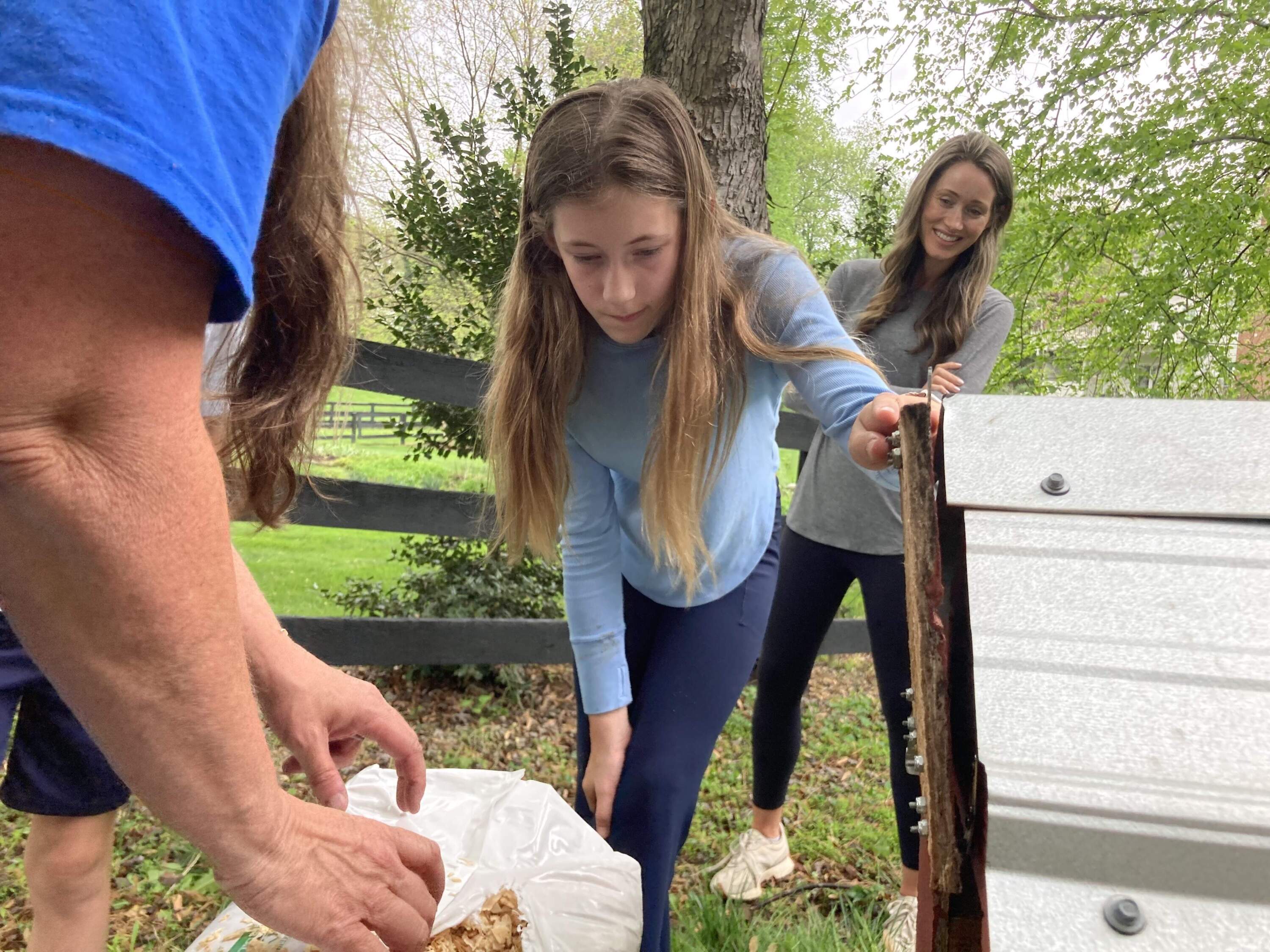 Charlotte McHonett, 12, helps set up the chicken coop. (Scott Tong/Here & Now)