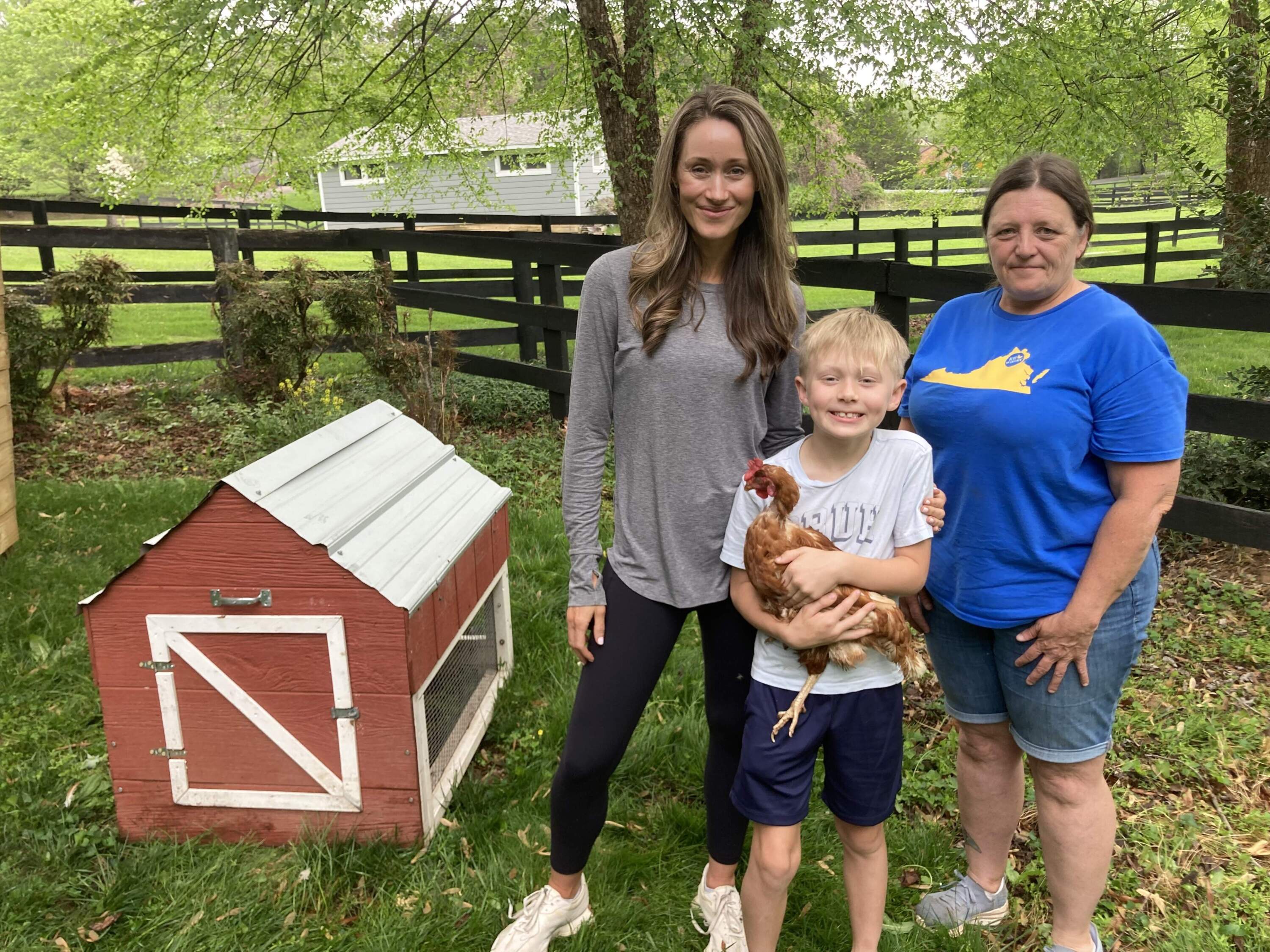 Jessica McHonett and her 8-year-old son Jack stand with Glenda Crum of Rent The Chicken and their new backyard chicken. (Scott Tong/Here & Now)