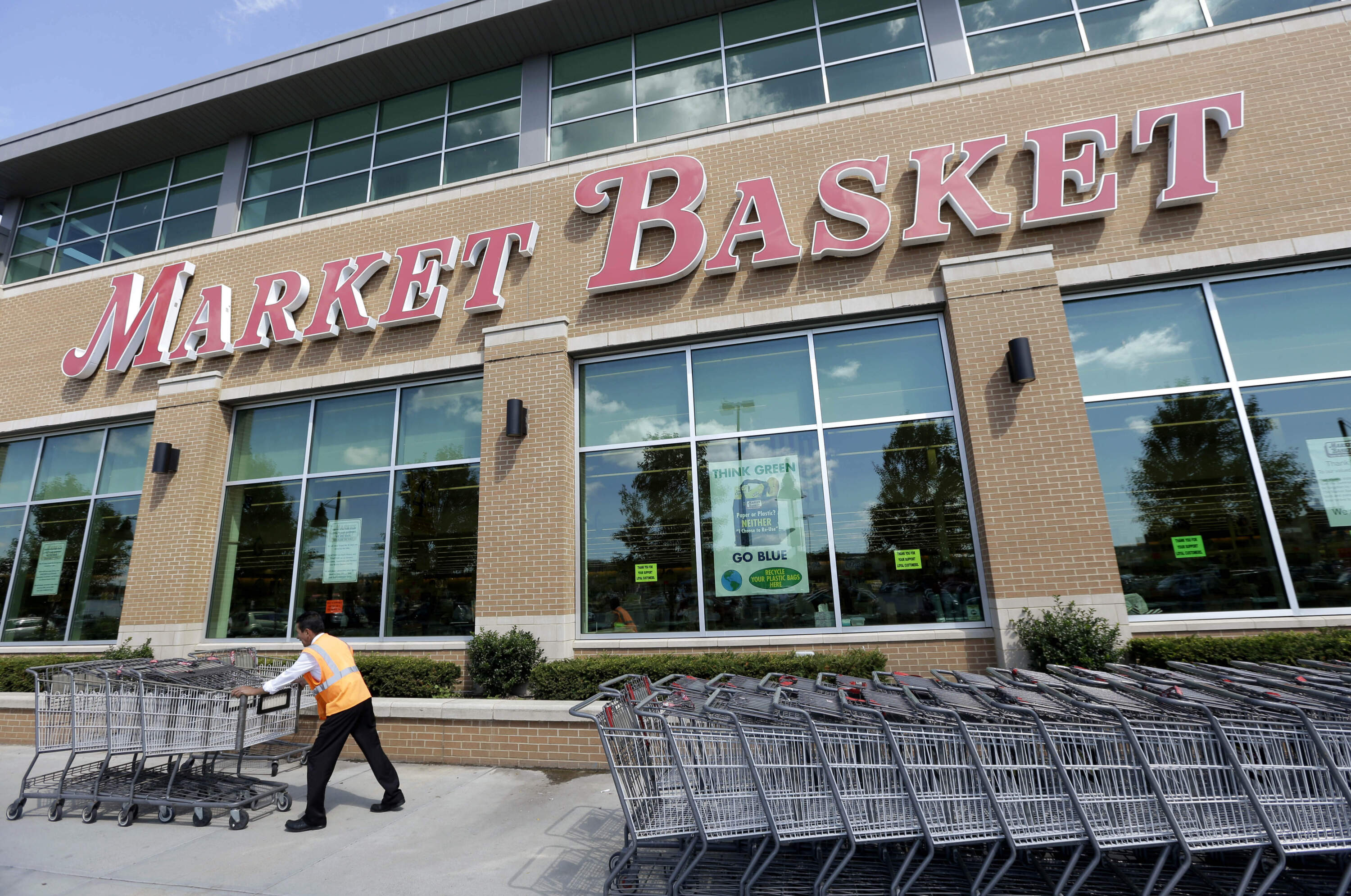A worker pushes grocery carts in front of a Market Basket supermarket location, Thursday, Aug. 28, 2014, in Chelsea, Mass. (Steven Senne/AP)