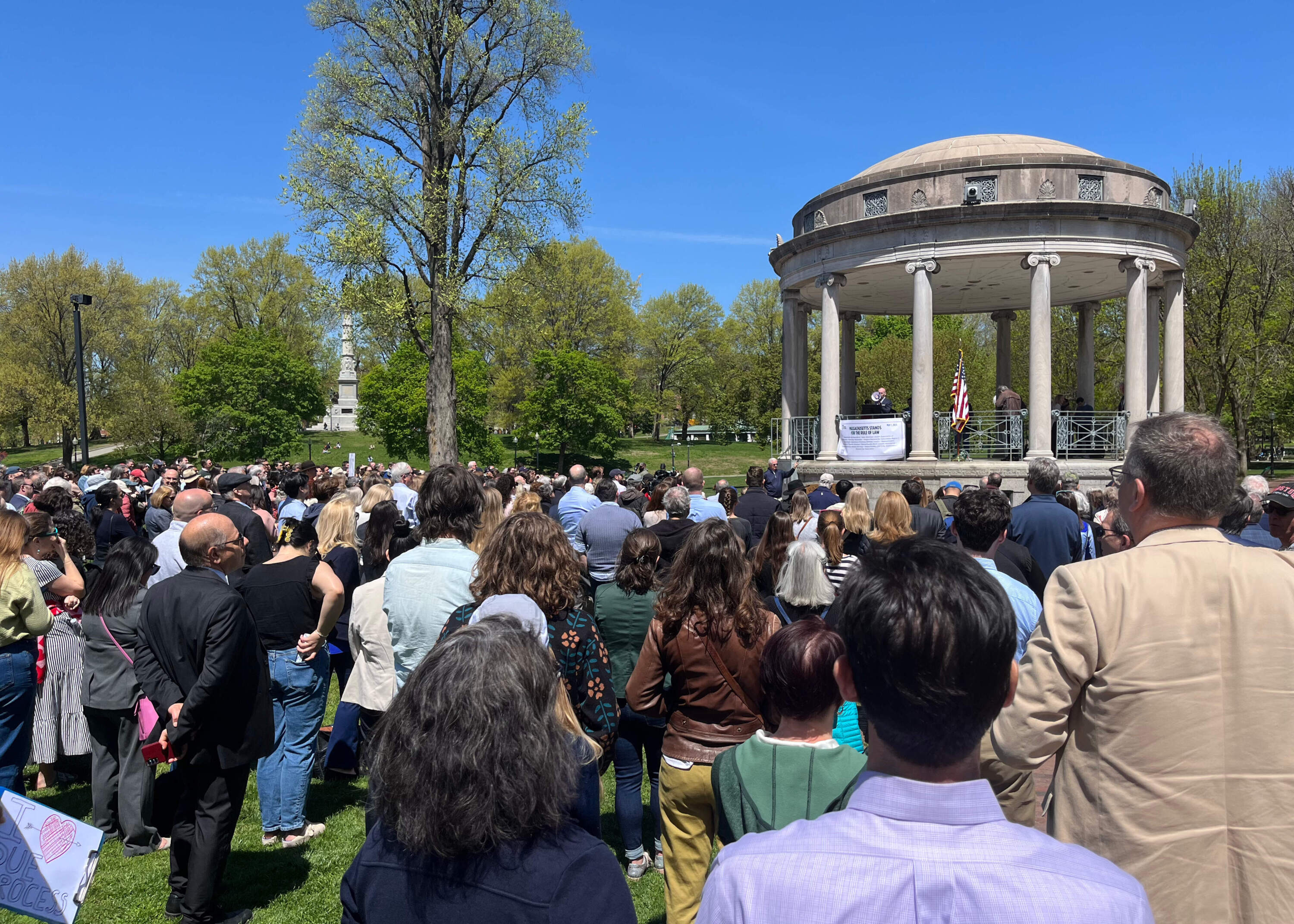Protesters listen to a speech at the National Law Day of Action protest at the Parkman Bandstand. (Chloe Jad/WBUR)