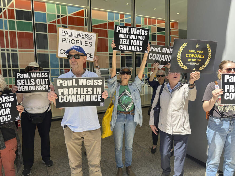 Demonstrators outside the law offices of Paul Weiss in New York on April 22 protest the firm's agreement to provide pro bono legal services for the Trump administration. (Ted Shaffrey/AP)