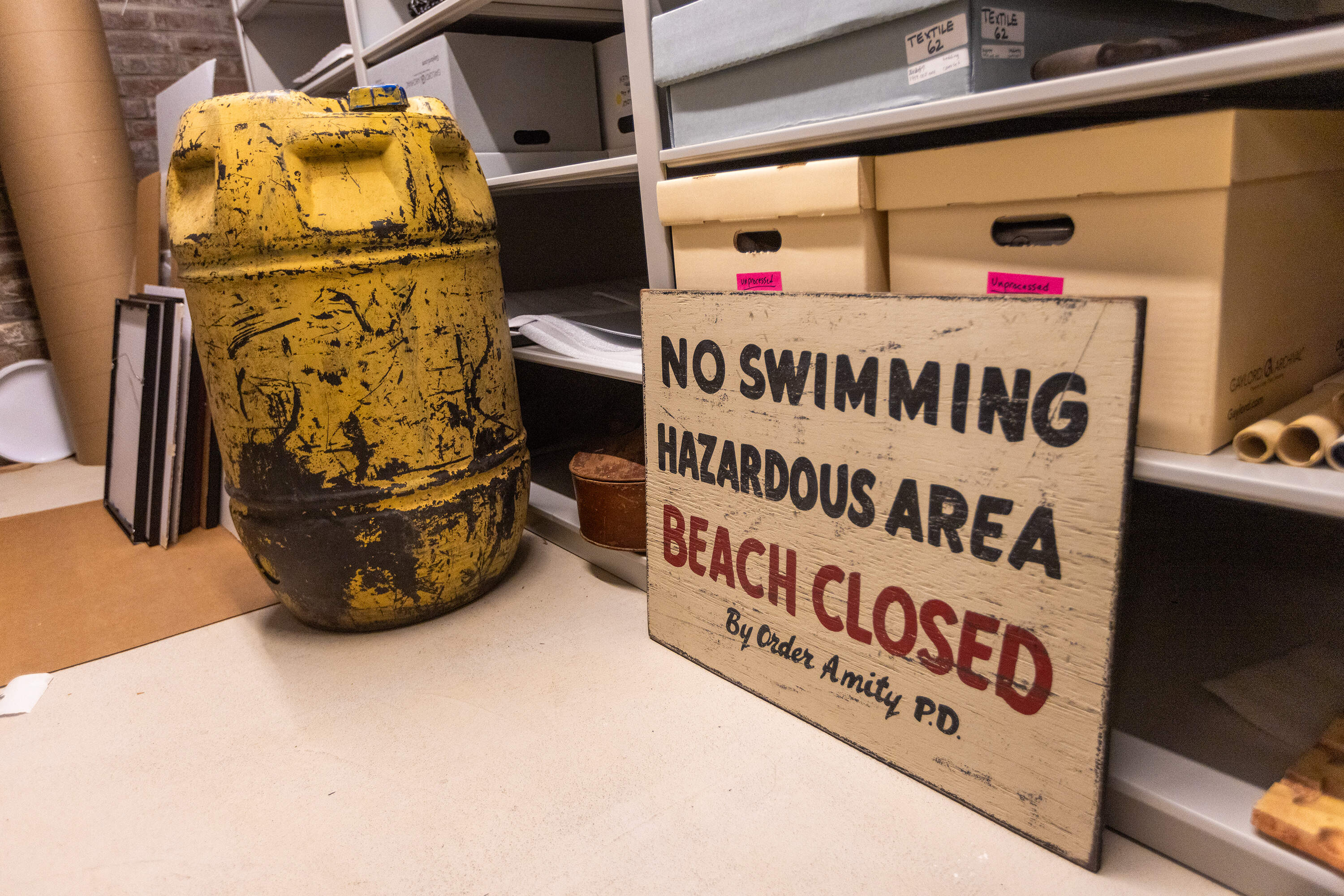 One of the iconic yellow barrels used in the film and lent to the Martha’s Vineyard Museum, and a replica of the "No Swimming" sign in the film. (Jesse Costa/WBUR)