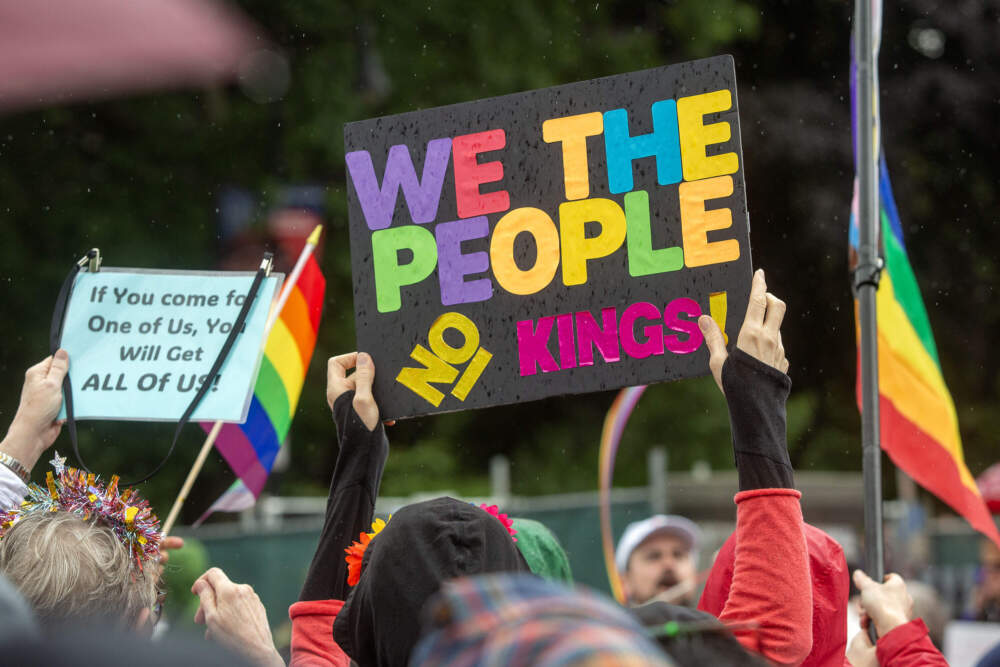 A demonstrator holds up a "No Kings" sign at the Boston Pride Parade. (Robin Lubbock/WBUR)