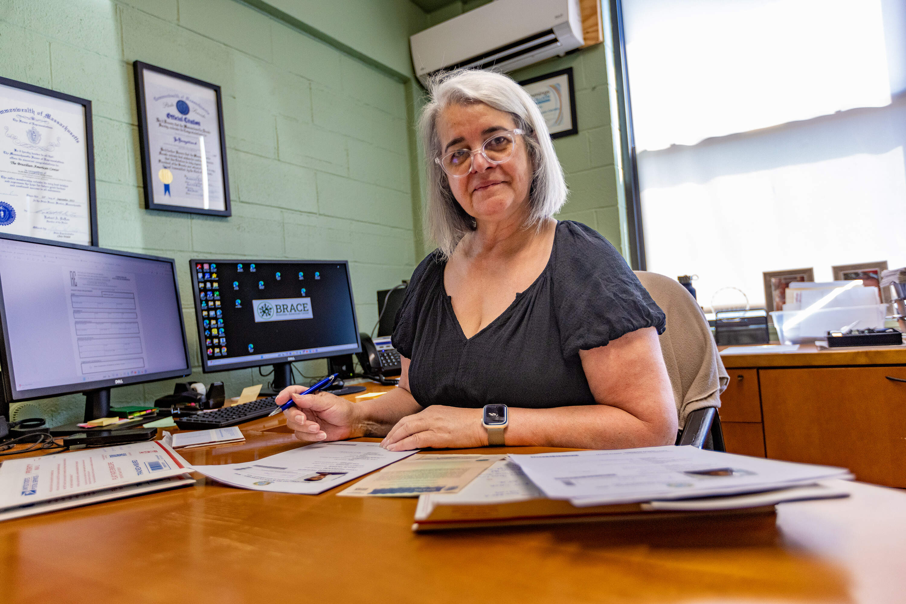 Executive director Liliane Costa sits in her office at the Brazilian-American Center in Framingham. (Jesse Costa/WBUR)