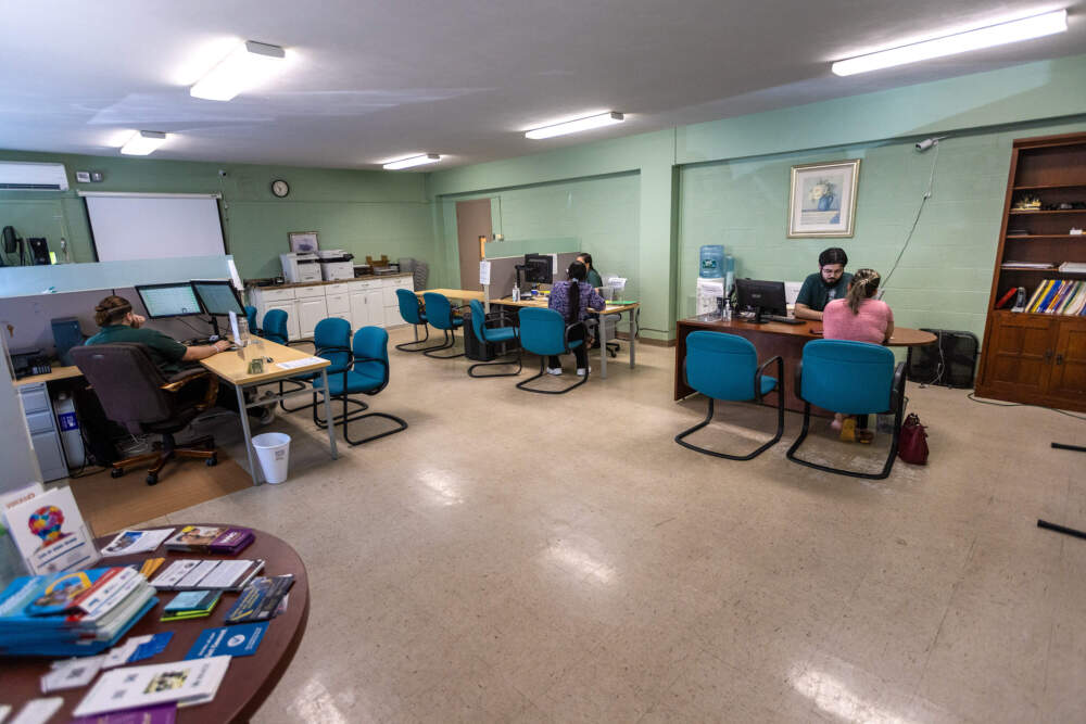 Two clients apply for health care assistance at the Brazilian-American Center in Framingham. (Jesse Costa/WBUR)