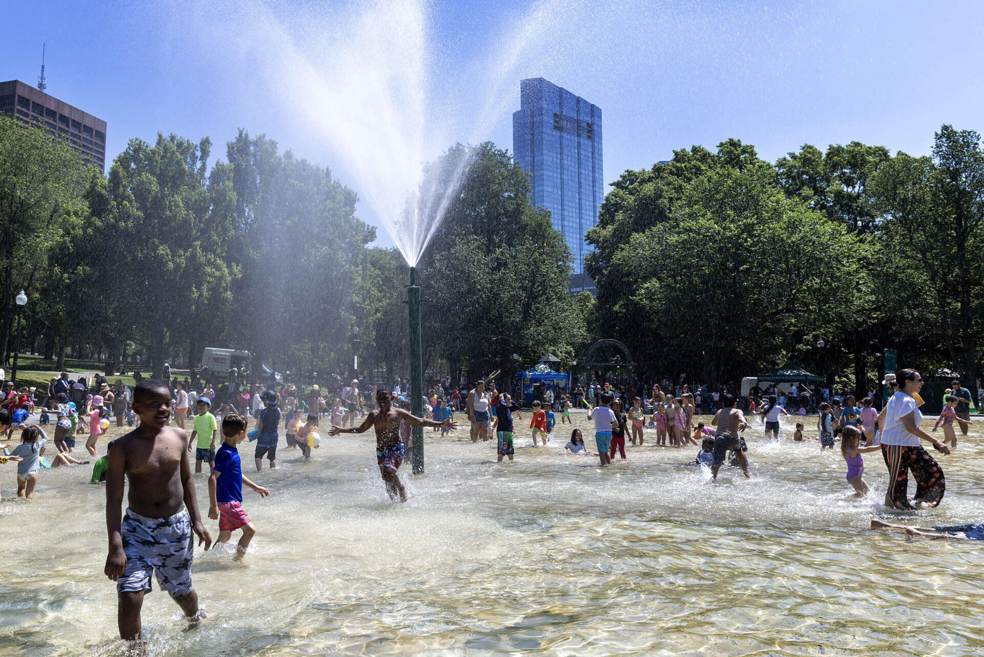 Water showers down from the fountain at the center of the Frog Pond, soaking bathers on the pond's opening day Boston. (Robin Lubbock/WBUR)