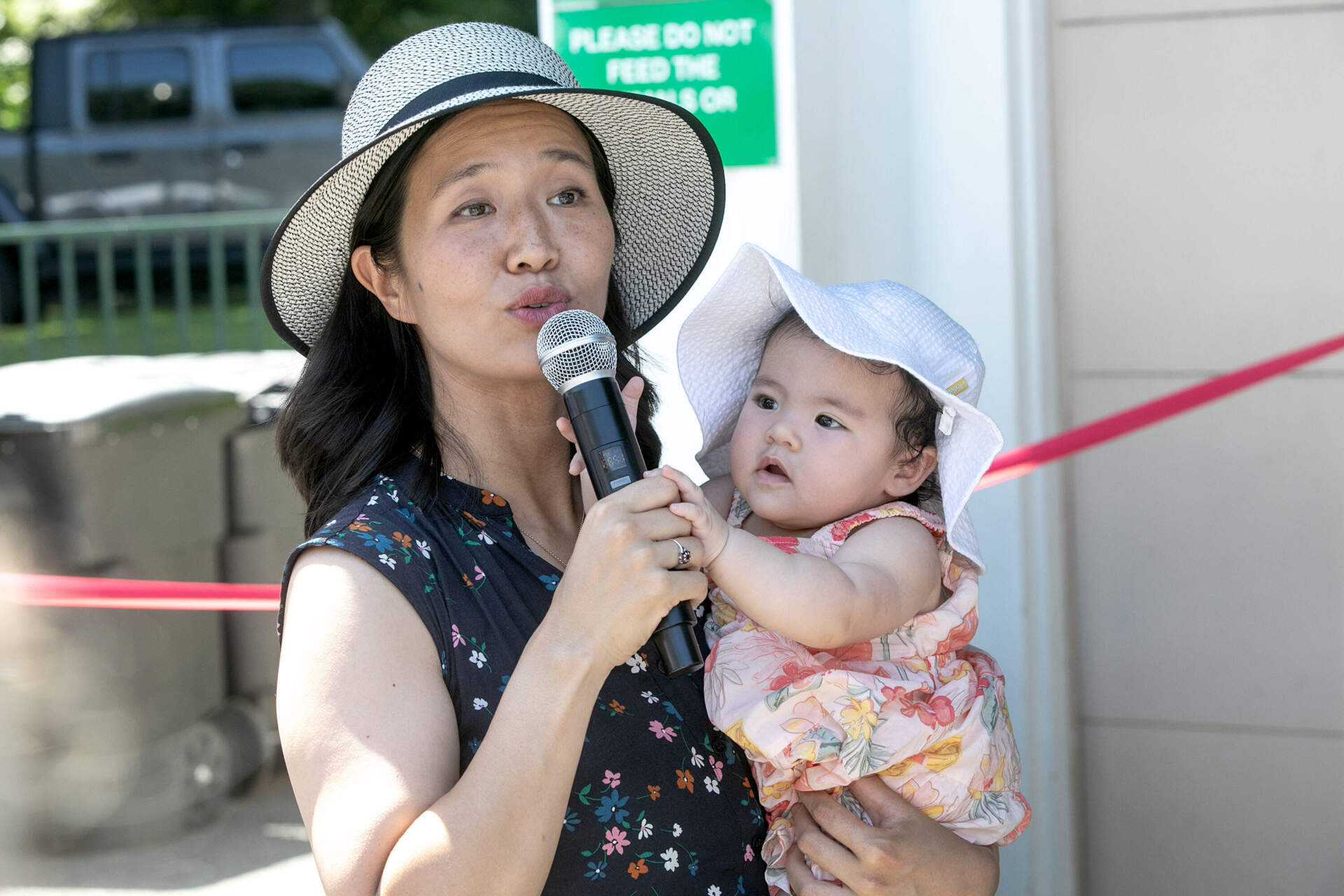 Mayor Michelle Wu speaks to the crowd of adults and children at the summer opening the Frog Pond on Boston Common. (Robin Lubbock/WBUR)