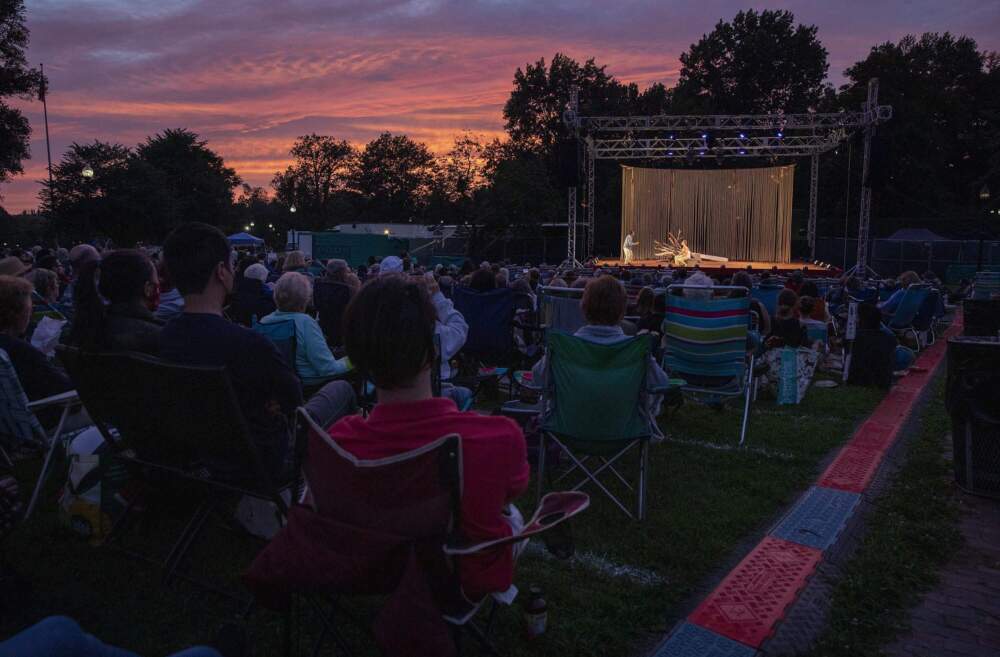 Sitting on deck chairs and blankets the audience watches the Commonwealth Shakespeare Company's performance of The Tempest during summer 2021. (Robin Lubbock/WBUR)