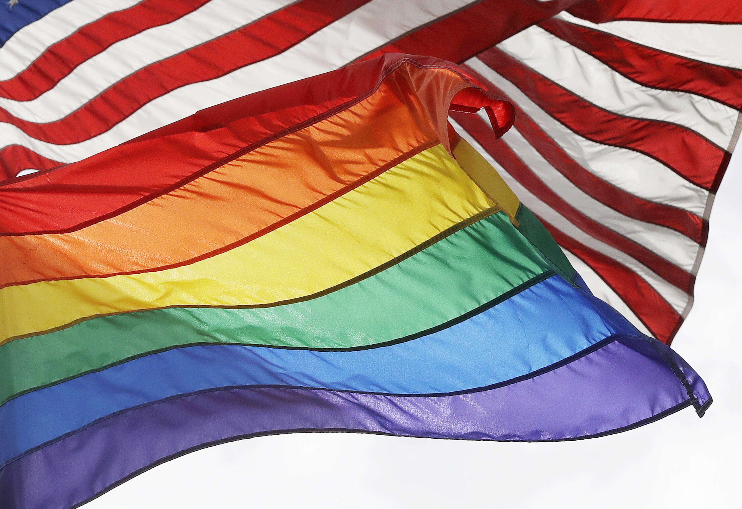 The LGBTQ+ pride flag flies beneath the American flag at the Stonewall National Monument, Oct. 11, 2017, in New York. (Mark Lennihan/AP)