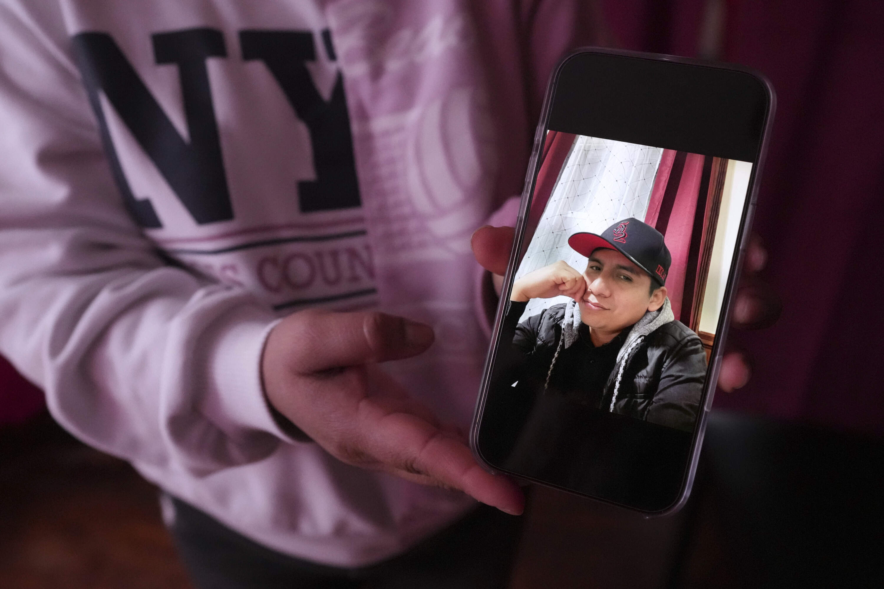 Marilu Domingo Ortiz, whose husband was taken into custody by ICE agents after they smashed a window of their family car, shows a photograph of her spouse, Juan Francisco Mendez, at their home, Wednesday, April 16, 2025, in New Bedford, Mass. (Charles Krupa/AP)