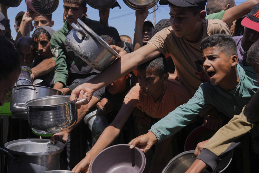 Palestinians struggle to get donated food at a community kitchen in Khan Younis, southern Gaza Strip, Monday, June 2, 2025. (Abdel Kareem Hana/AP)