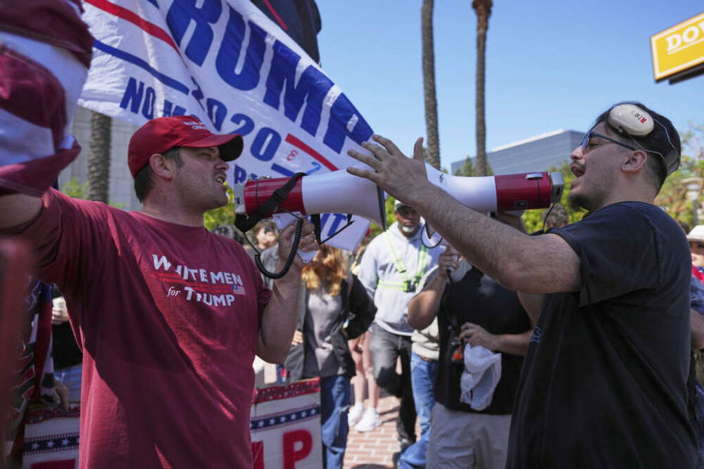 A protester wearing a shirt reading "WHITE MEN for TRUMP" argues with another protester Tuesday in Santa Ana, California. (Jae C. Hong/AP)