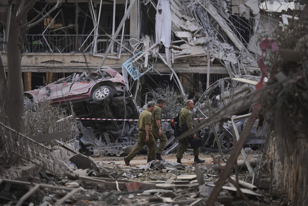 Israeli security forces inspect destroyed residential buildings that were hit by a missile fired from Iran, in Ramat Gan, near Tel Aviv, Israel, on Saturday, June 14, 2025. (AP Photo/Ariel Schalit)