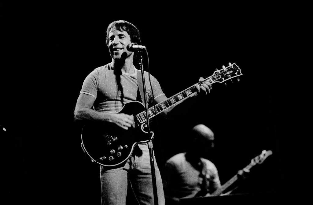 American Folk and Pop musician Paul Simon plays guitar as he performs onstage at the Auditorium Theater, Chicago, Illinois, September 25, 1980. (Photo by Paul Natkin/Getty Images)