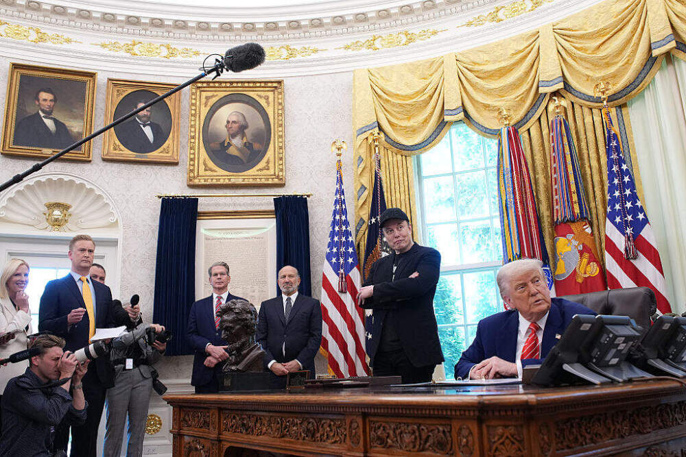 Elon Musk and President Trump listen to a question from a reporter in the Oval Office of the White House on May 30, 2025. (Kevin Dietsch/Getty Images)