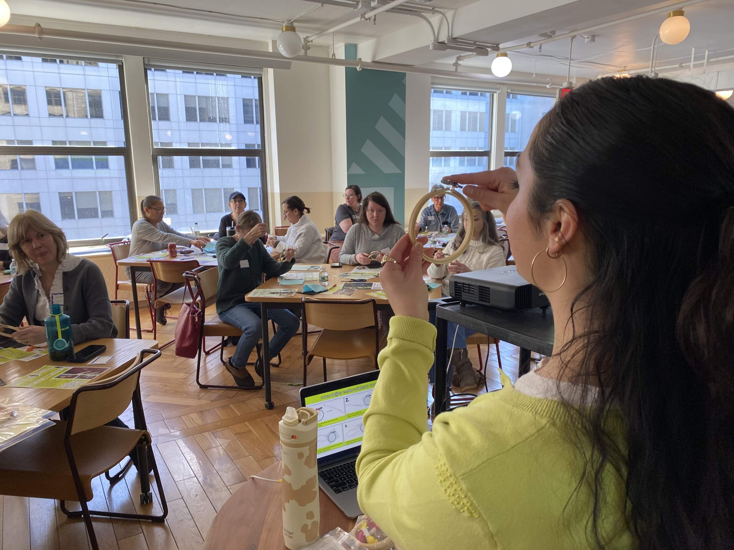 Megan Burke leads a public stitching tutorial at the community space in Boston's School of Fashion Design. (Andrea Shea/WBUR)