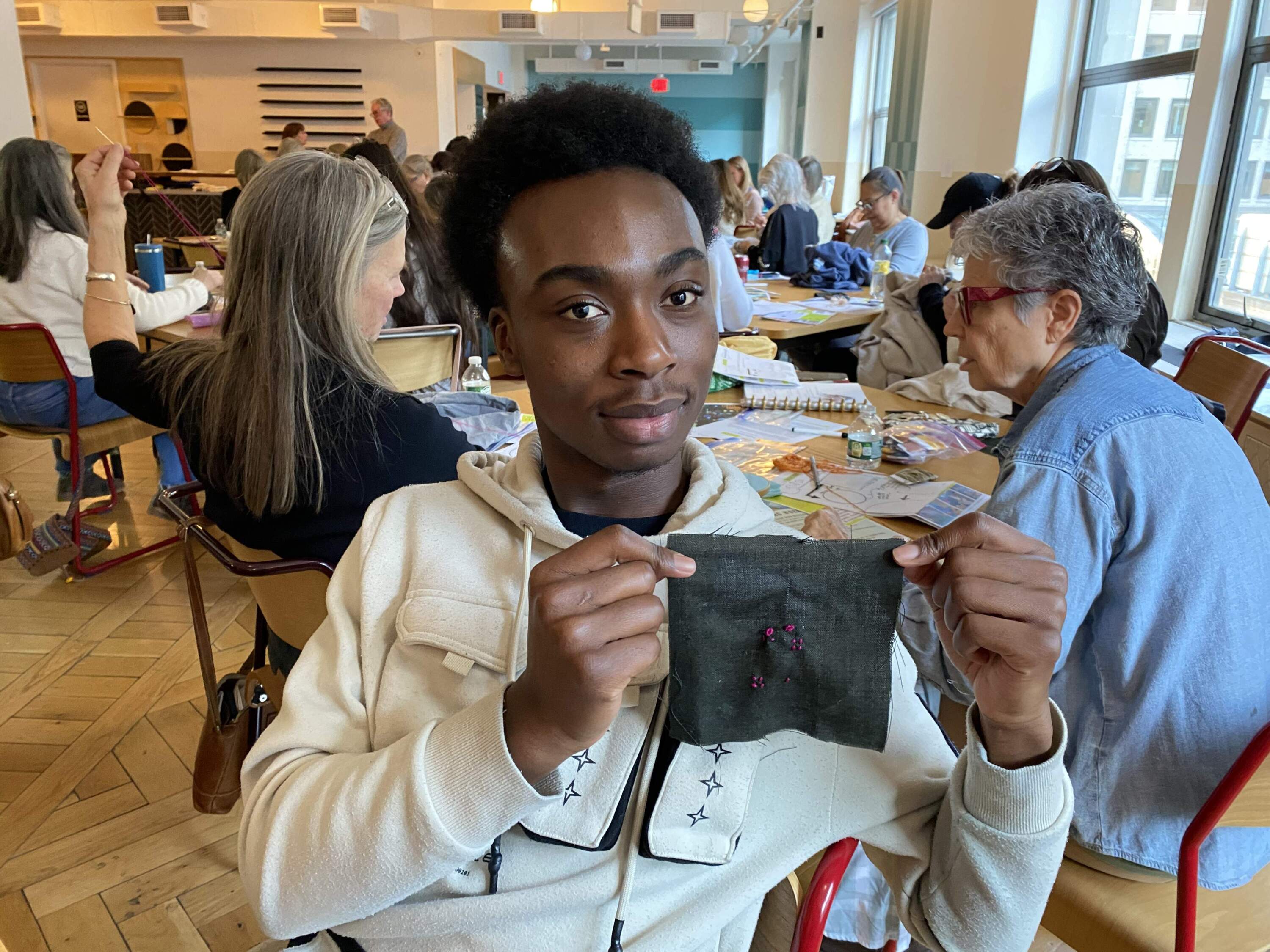 Pious Baidoo is working towards becoming a psychiatrist and says learning about cuerdos stitching is in line with his his career goals. (Andrea Shea/WBUR)