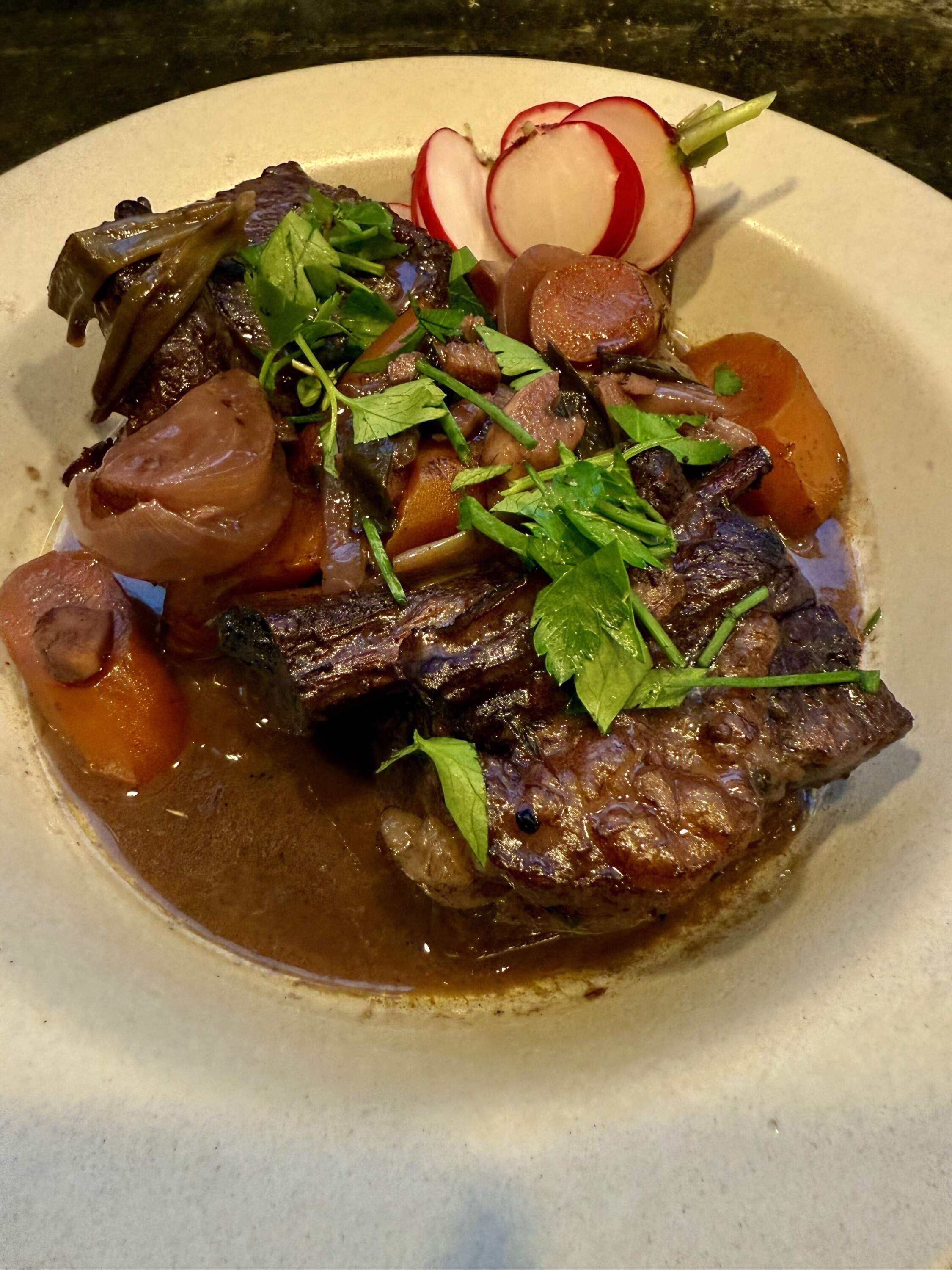 Braised short ribs with red wine, onions, ginger, carrots and herbs. (Kathy Gunst/Here & Now)