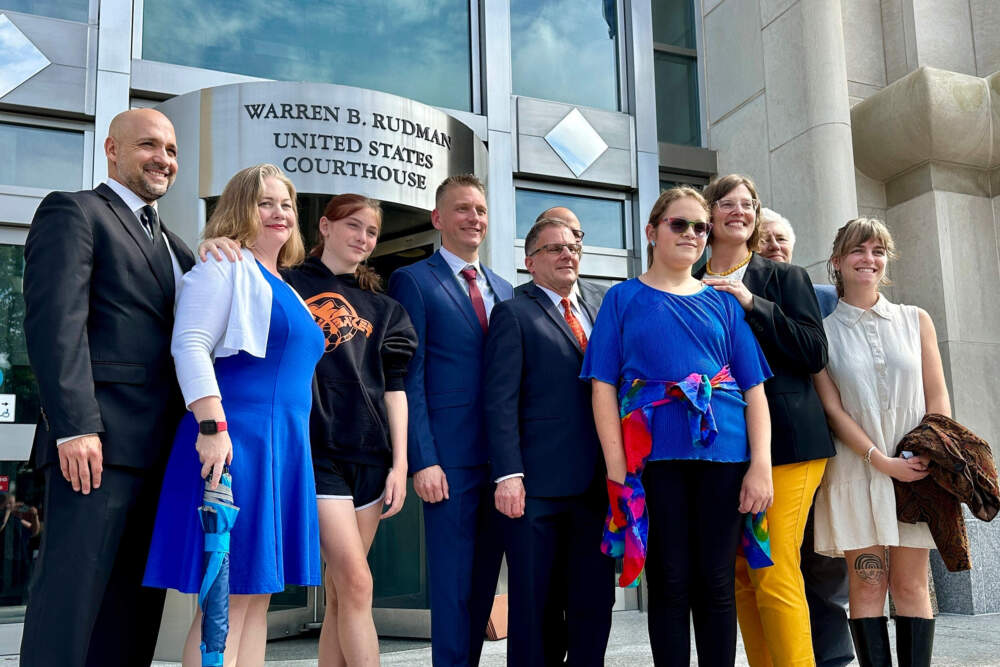 Two teens challenging New Hampshire's new law banning transgender girls from girls' sports teams pose with their families and attorneys in Concord, N.H., Monday, Aug. 19, 2024, after a judge granted an emergency request to allow one of the girls to play soccer while their lawsuit continues. (Holly Ramer/AP)