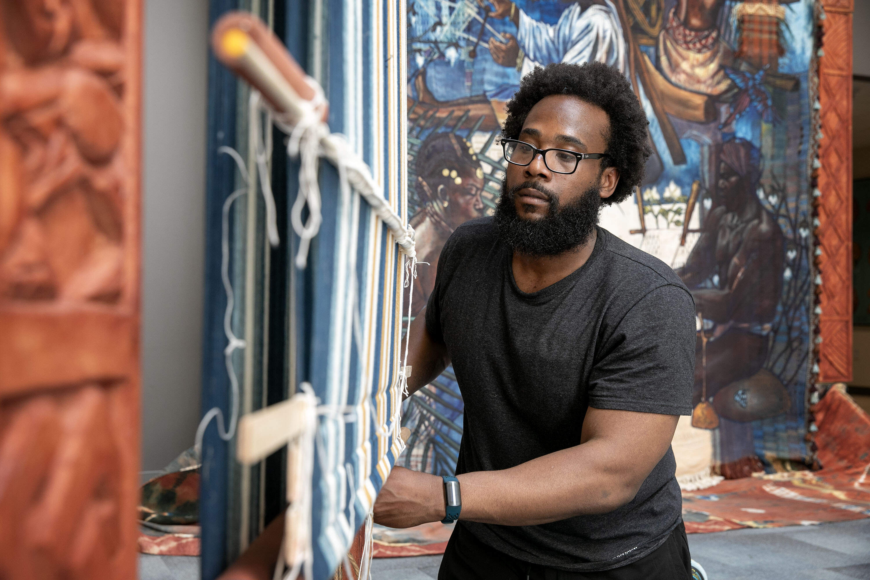 Artist Stephen Hamilton makes an adjustment to his installation "Under the Spider's Web" at Roxbury Community College, in Boston. (Robin Lubbock/WBUR)