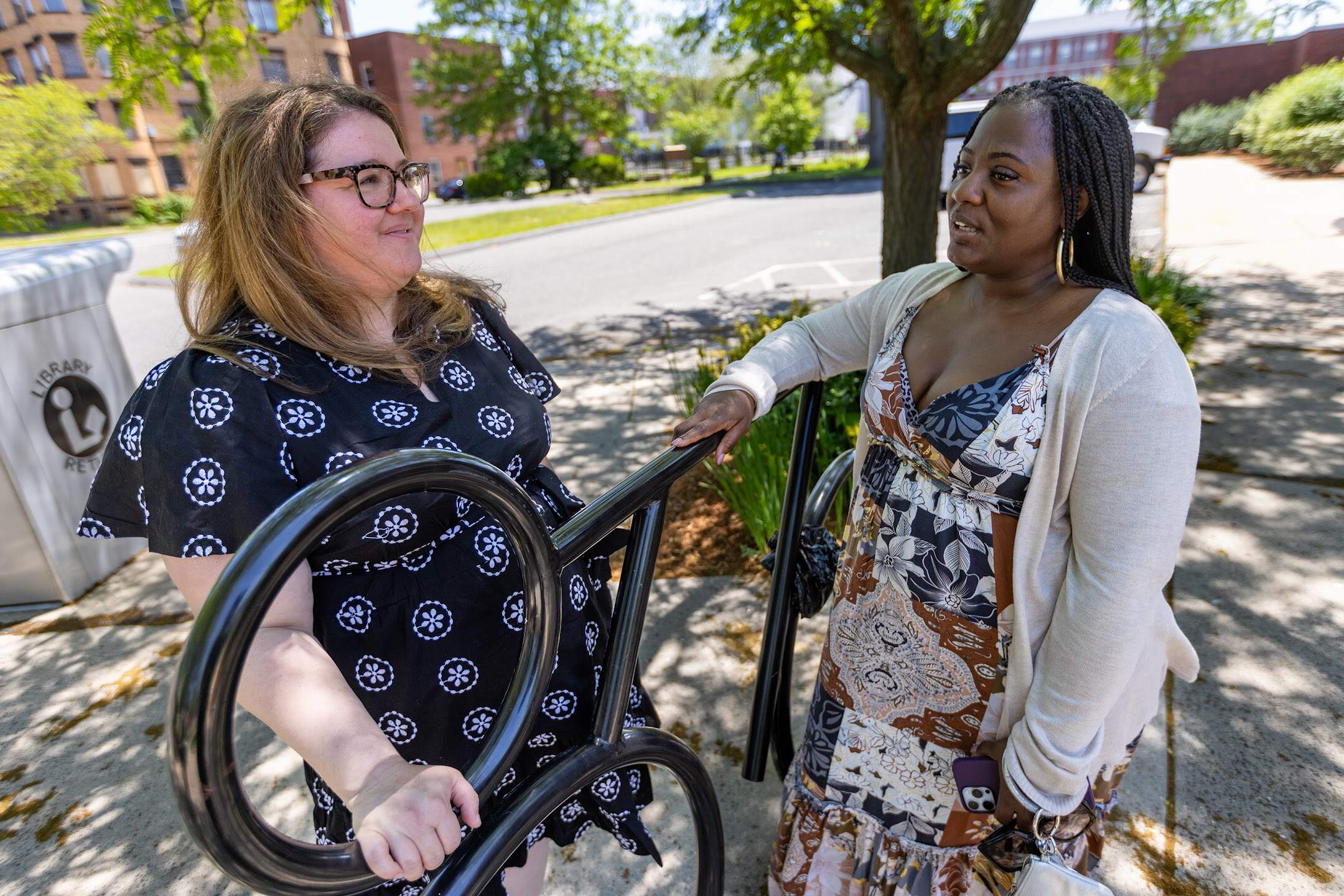 Tina Quagliato-Sullivan, Deputy Development Officer for Housing, Community Services & Sustainability for the City of Springfield, speaks with Springfield City Councilor Tracye Whitfield at the Mason Square Branch of the Springfield Public Library. (Jesse Costa/WBUR)