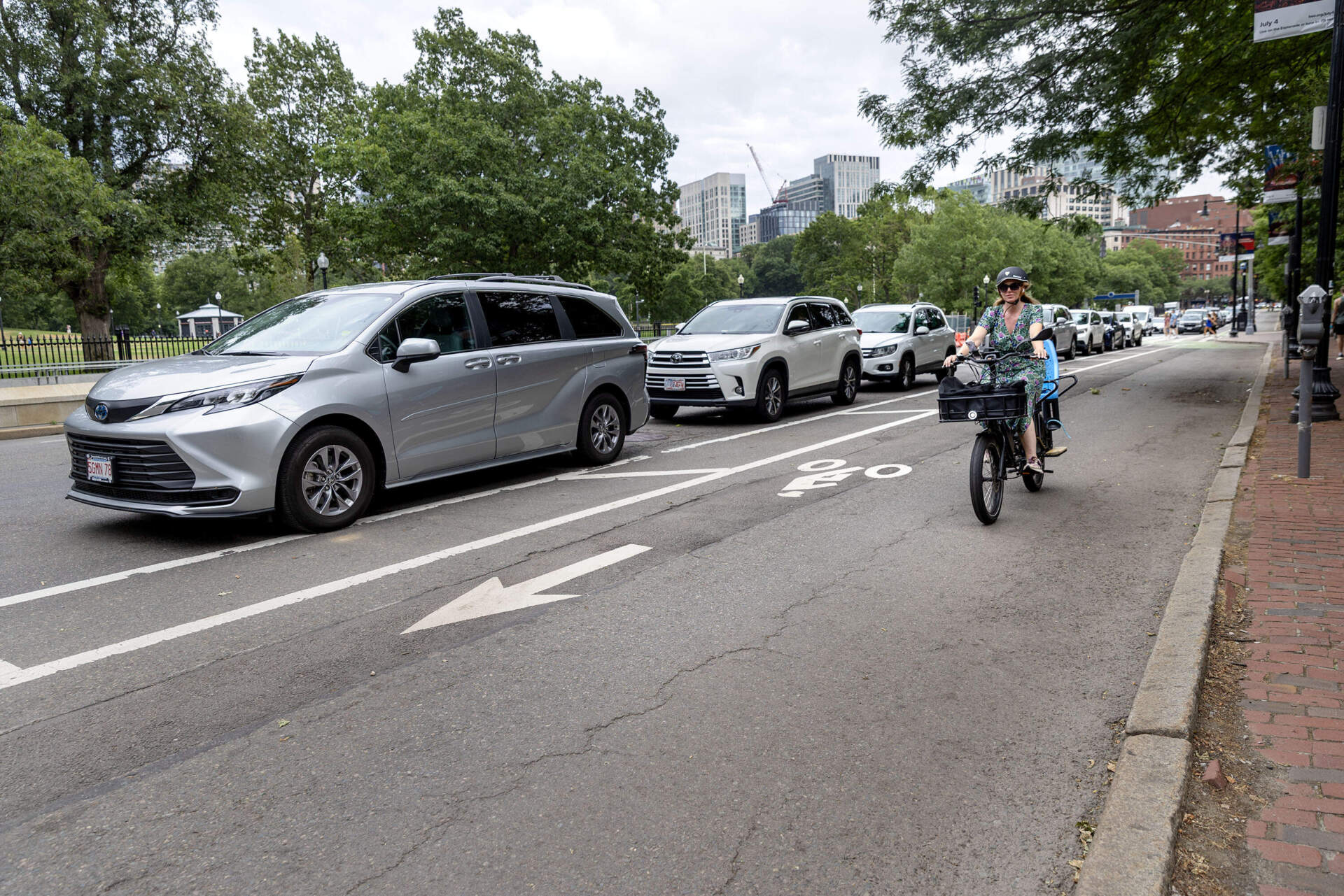 A cyclist rides along Charles Street by Boston Common in a wide bike lane. (Robin Lubbock/WBUR)