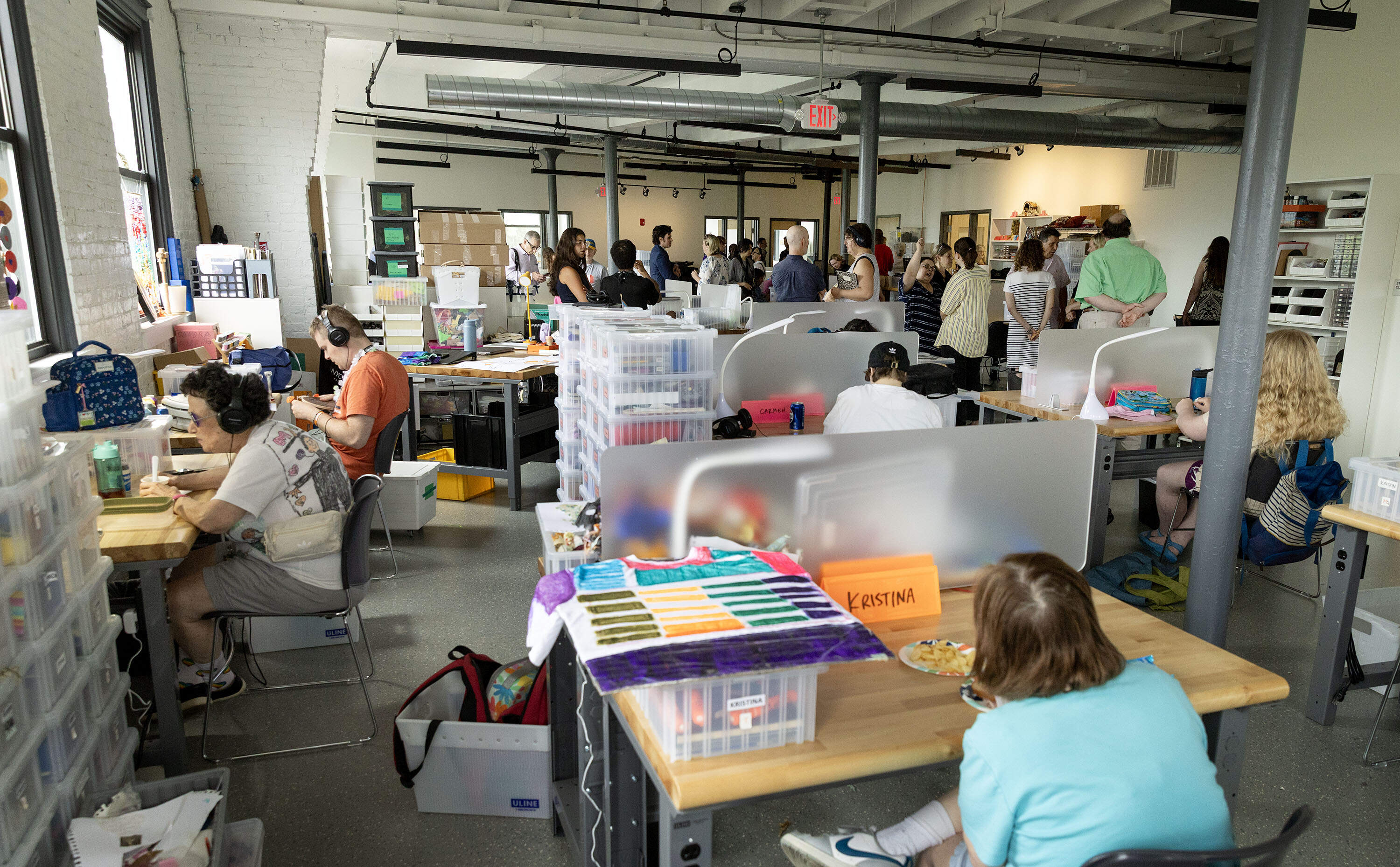 Artists and visitors fill a large studio space on opening day at Gateway Arts in Brookline. (Robin Lubbock/WBUR)