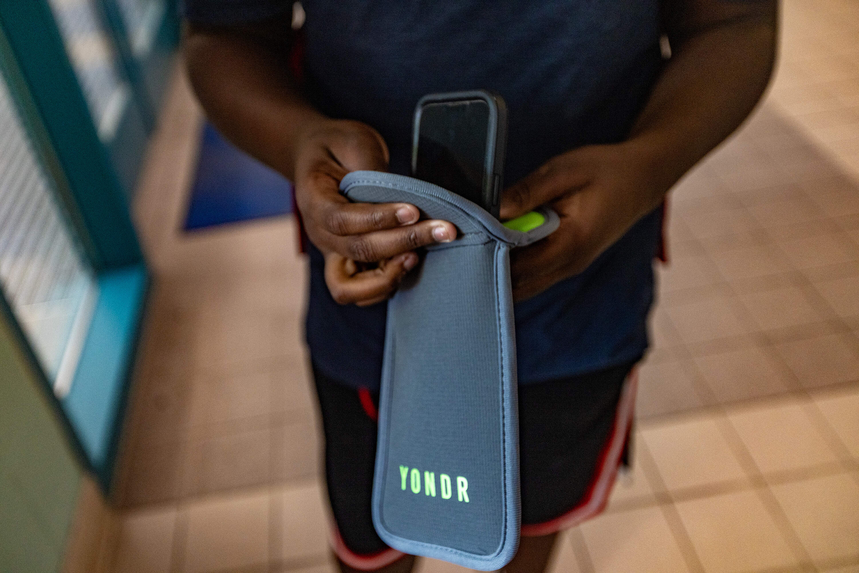 A middle school student in Salem places his cellphone into a Yondr pouch.
