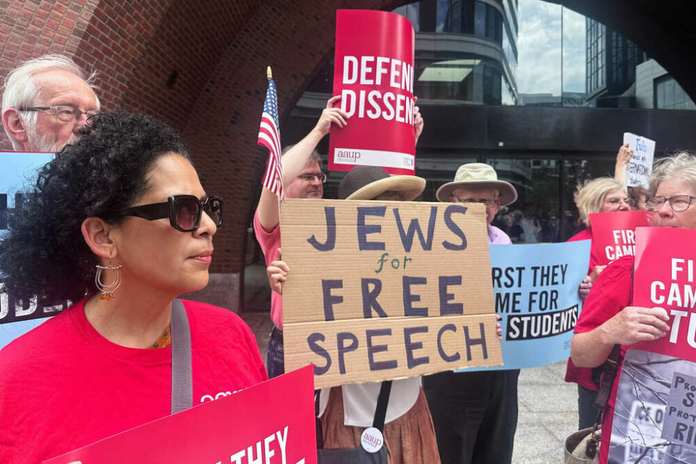 People hold signs outside of the federal courthouse in Boston on Monday as a lawsuit challenging the Trump administration's policy of targeting students for deportation who took part in pro-Palestinian demonstrations goes to trial. (Michael Casey)