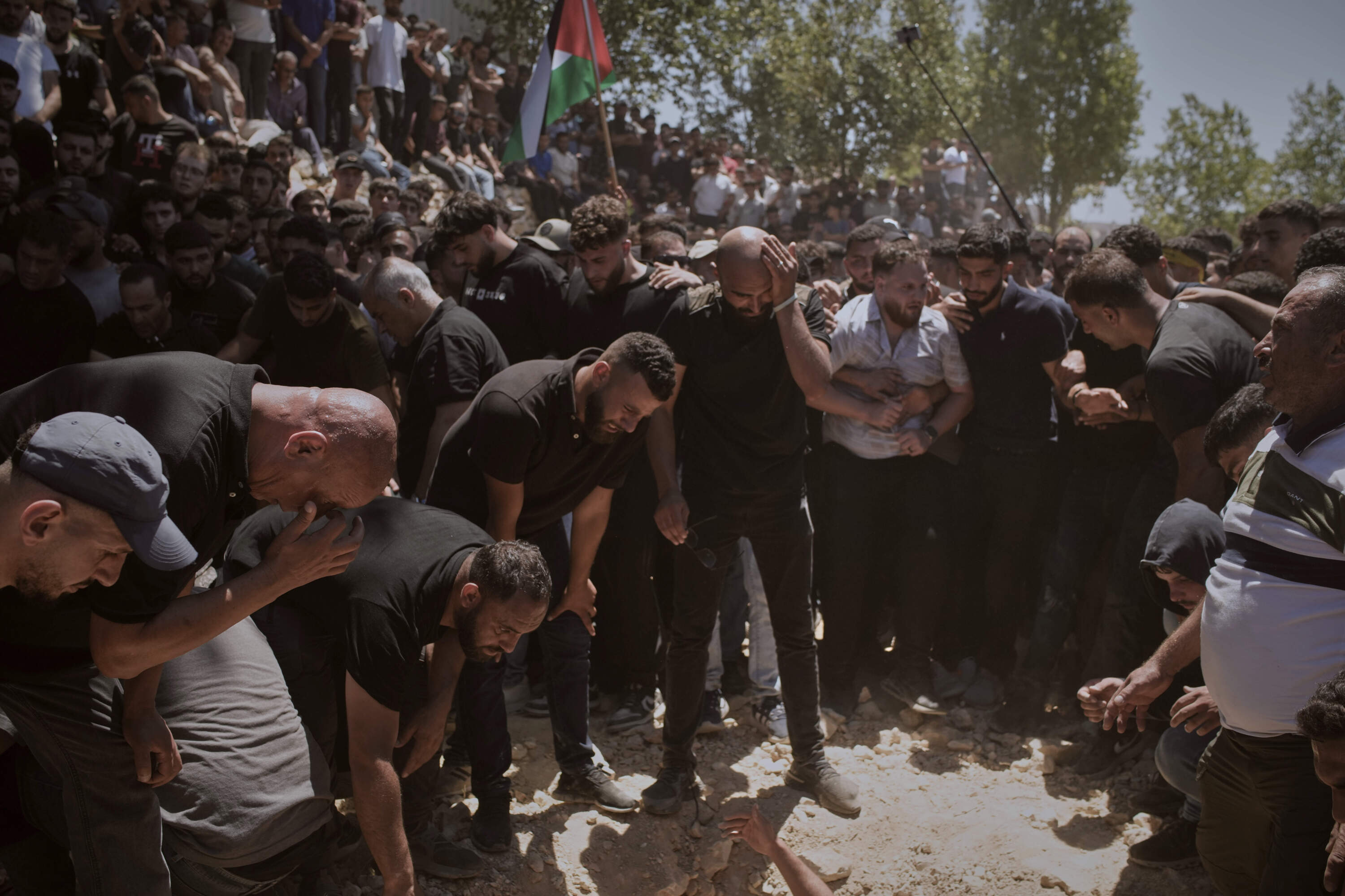 Mourners gather around the graves of Palestinian-American Sayfollah Musallet, 20, and Mohammed al-Shalabi during their funeral in the West Bank village of Al-Mazraa a-Sharqiya on Sunday, July 13, 2025. According to the Palestinian Health Ministry, Musallet was killed in an attack by Israeli settlers and al-Shalabi was shot in the chest. (Leo Correa/AP)